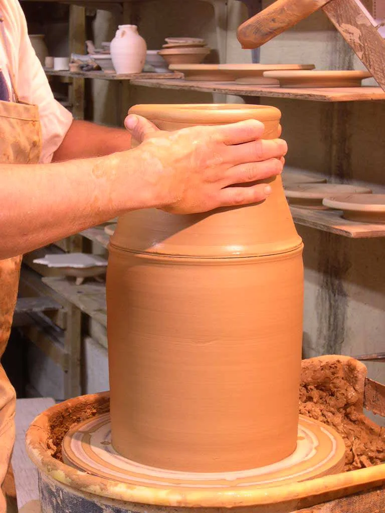 Here I am adding the "cap" that I actually made before I threw the bottom section. I measured the cap before I took it off the wheel with my calipers, then set it aside. The cap is slightly smaller than the bottom section. One advantage to capping is that the clay is still wet and can still be stretched and thrown. The other advantage is that the torque in the clay, or the throwing lines are in the same direction in both sections.