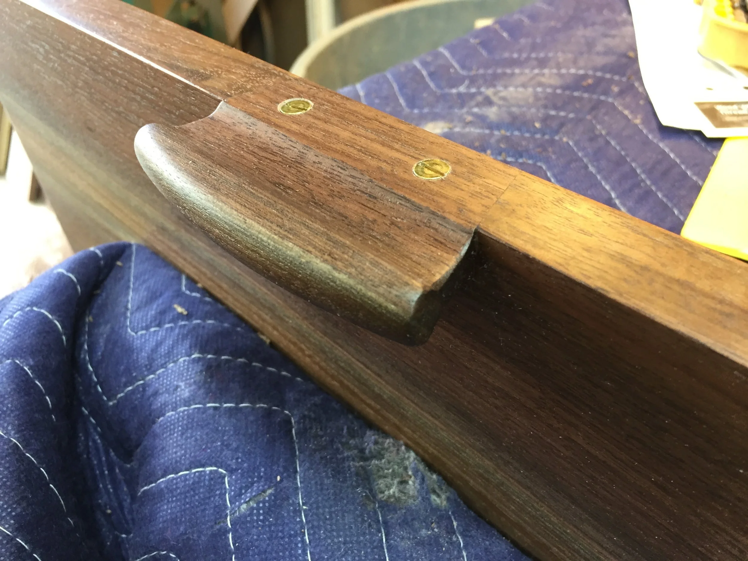 The pull glued in place, reinforced with brass screws