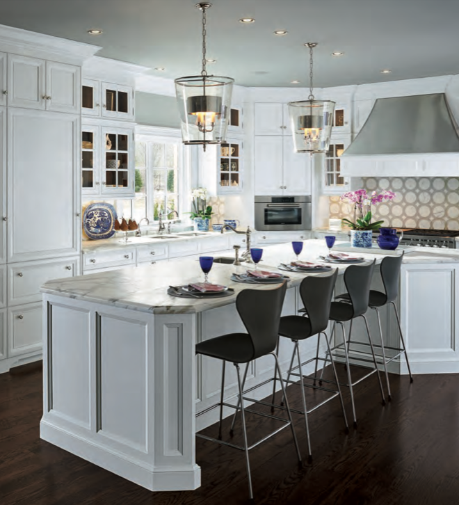 Kitchen with white cabinets, marble island, black chairs, pendant lights, and dark hardwood flooring.