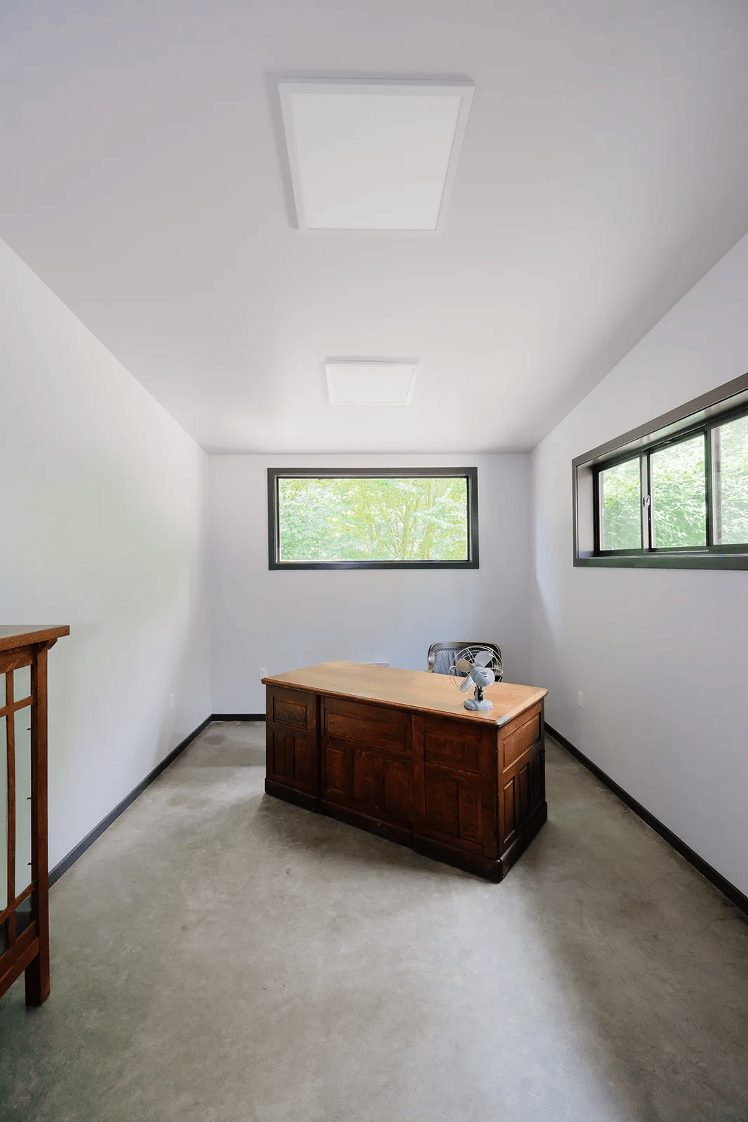 Separate home office with a wooden desk and windows in the Vashon Hangar Home