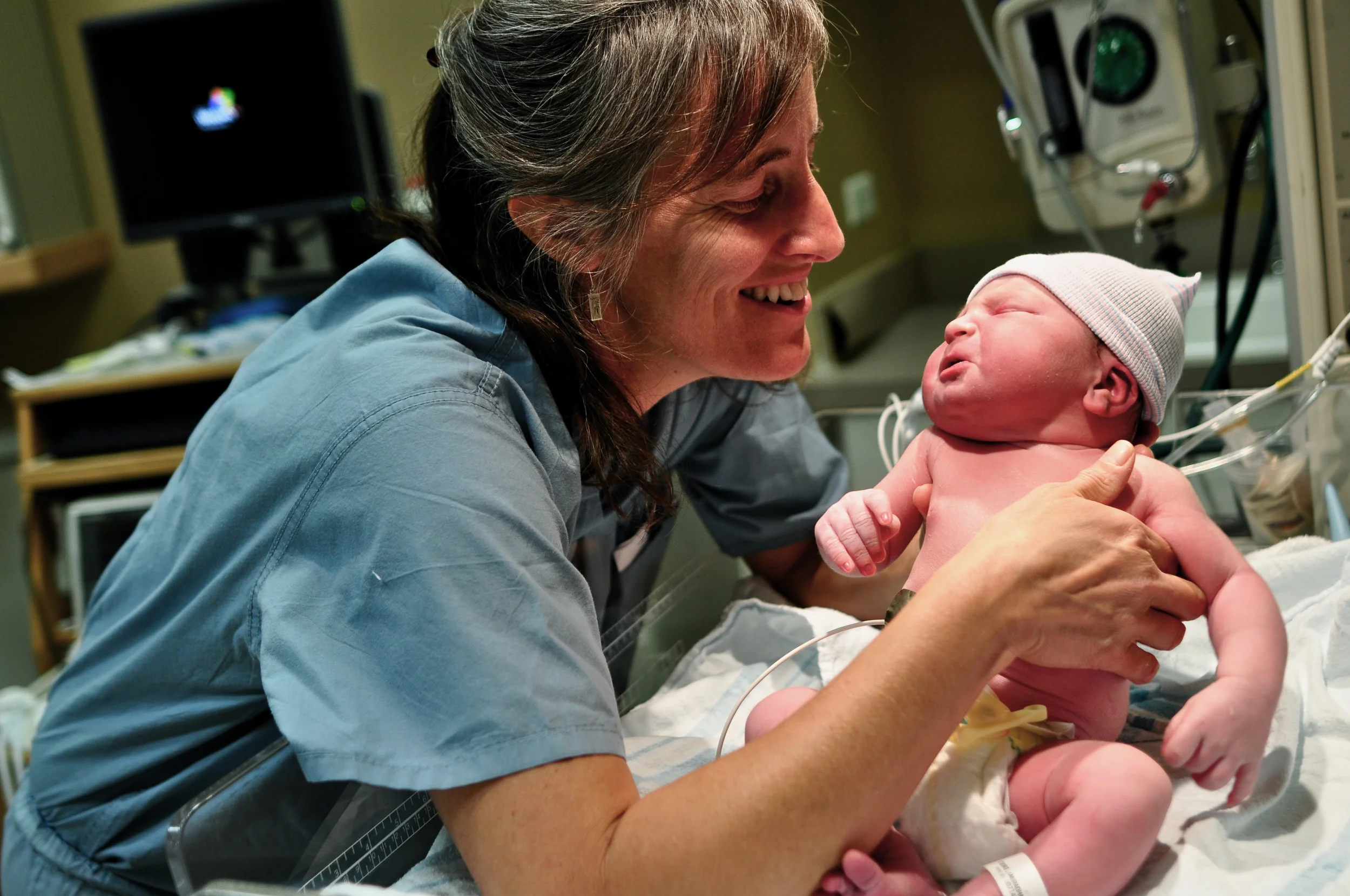 Midwife Amy assesses a healthy newborn. The midwife works to keep mom and baby safe and healthy throughout pregnancy, birth and postpartum. To do that she monitors vital signs, draws and interprets labs, educates clients on tests and interventions, and is trained in normal birth, as well as emergency techniques. She works within the medical community and refers clients to outside providers as needed. Photo by Sandor Weisz