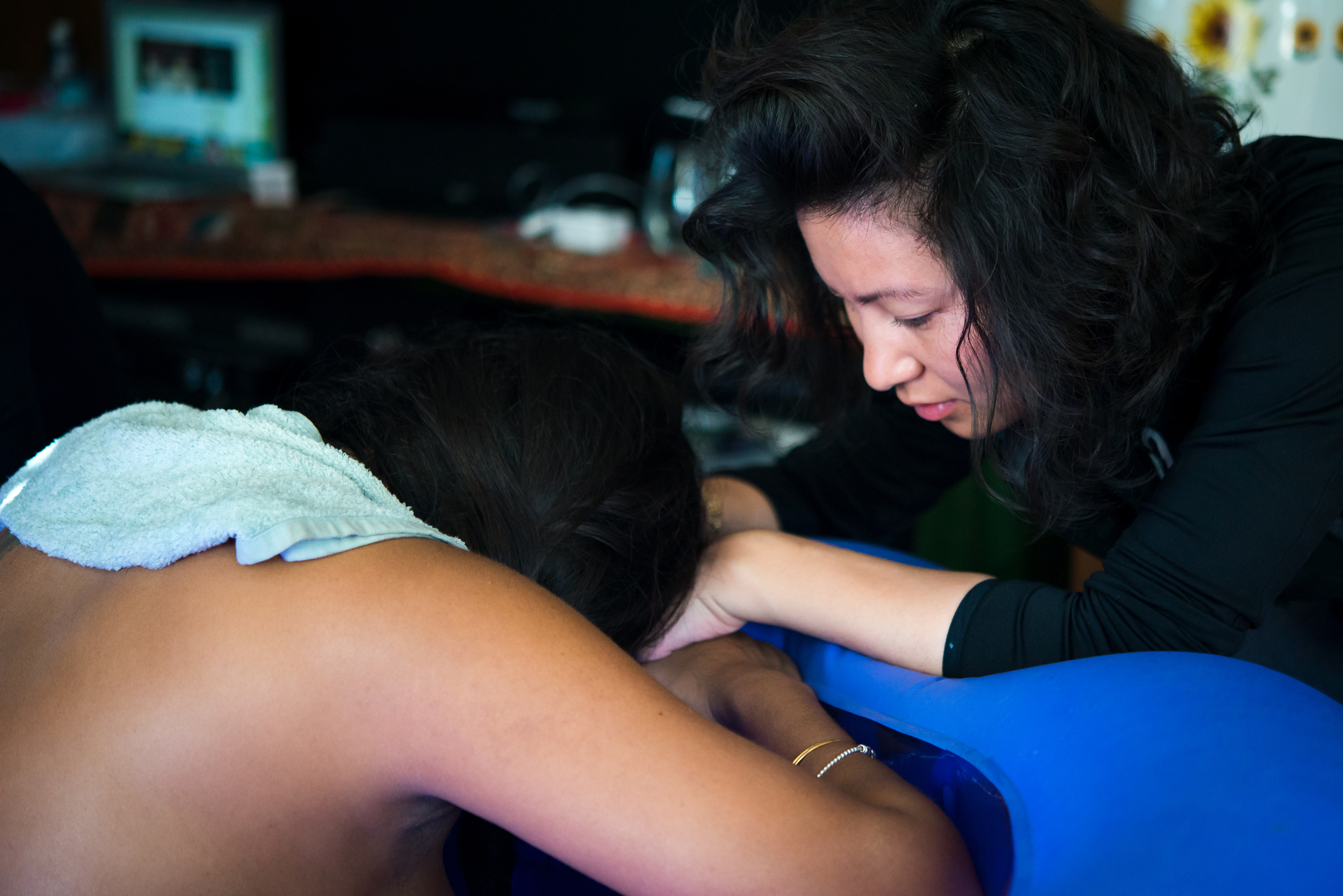 Doula Yien supports a mama having a natural delivery at home by keeping her calm, focused, and on top of her contractions. Yien provides continuous physical and emotional support until the baby is born, never leaving the mom's side. Photo by Pam Ellis