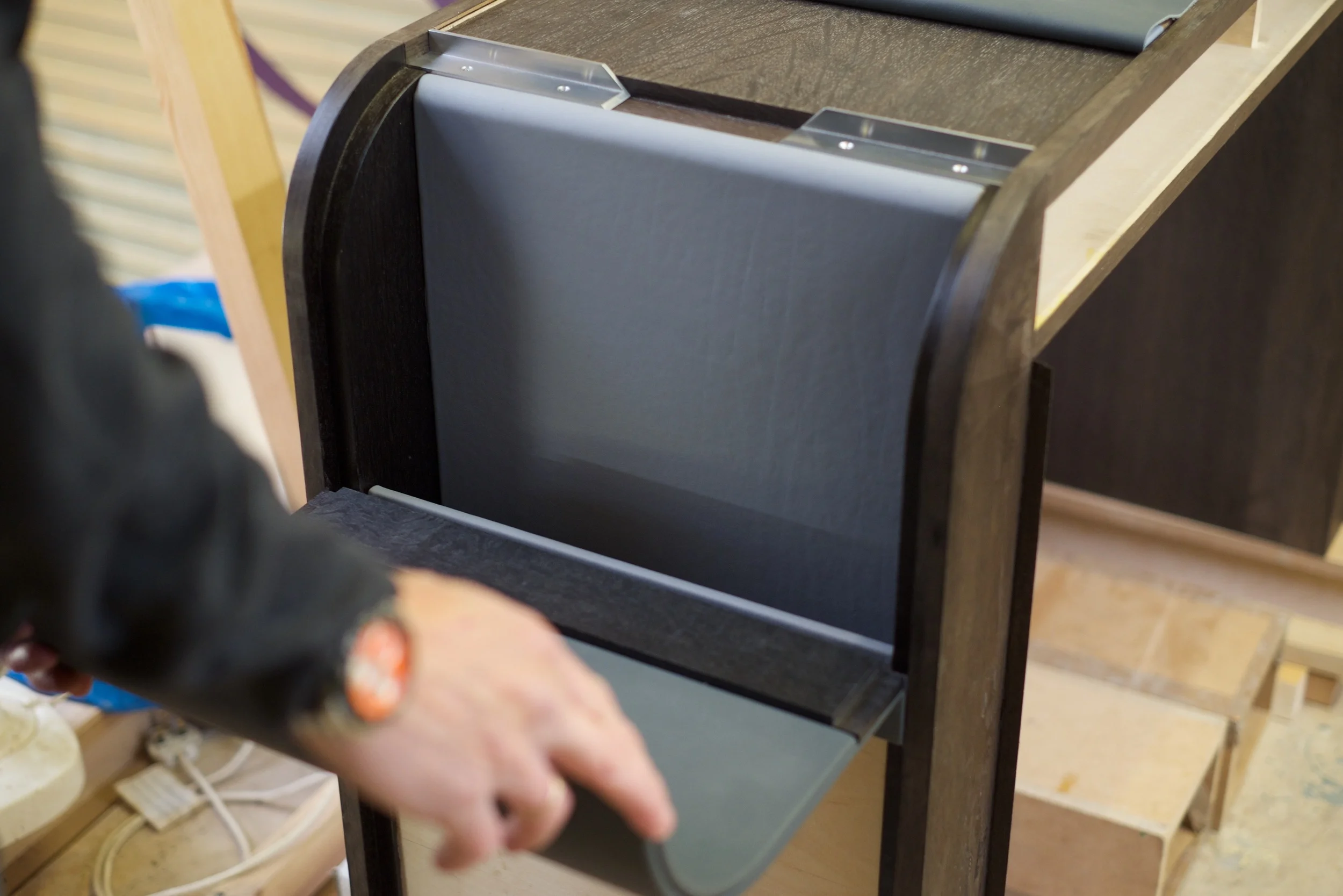 The storage door opens fully, resting flat against the desk leg. The door is hinged using concealed soss hinges. 