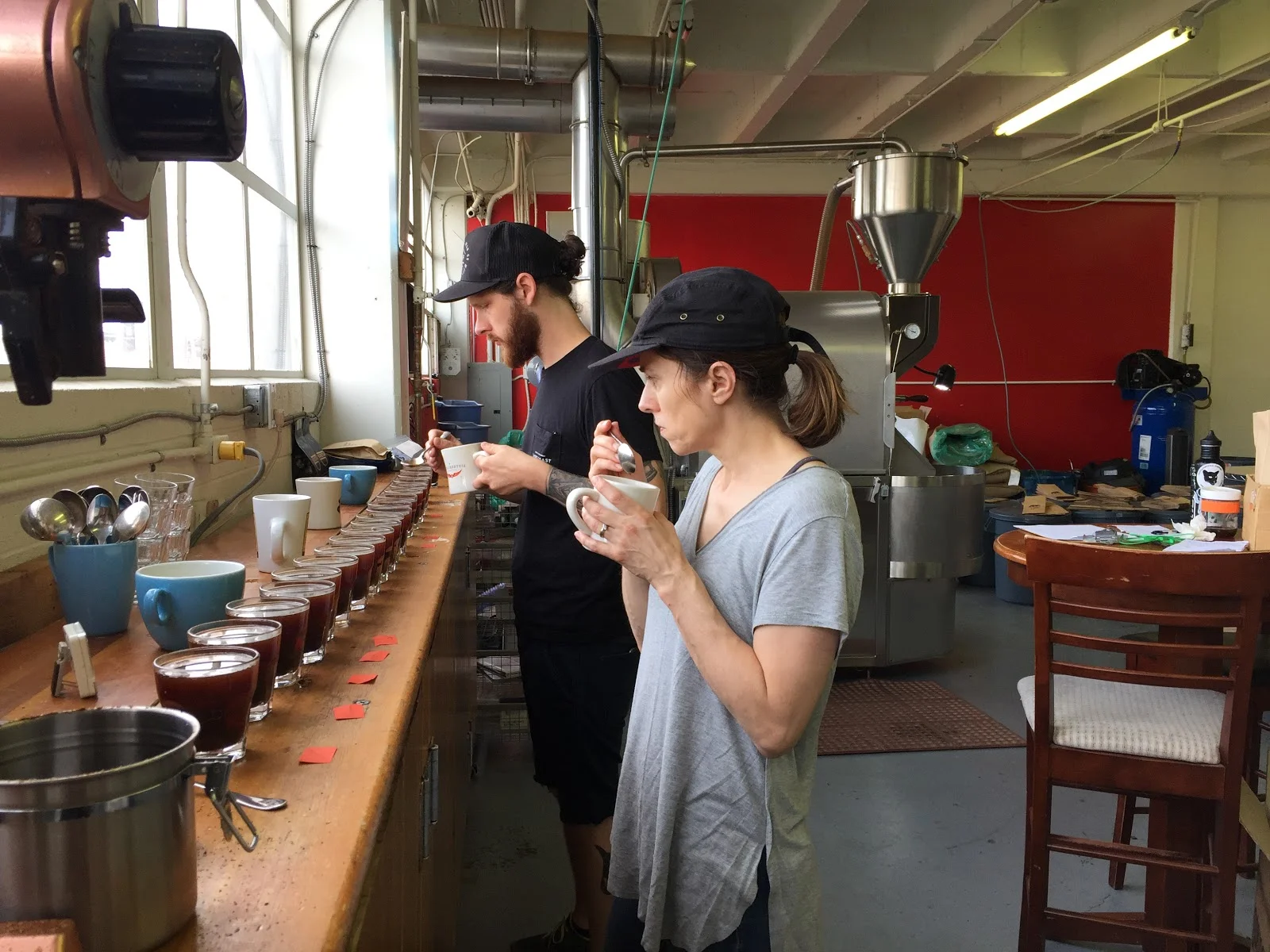 Staff Joel Harrison and Christine Esparolini cupping production (Photo courtesy of Kuma Coffee)