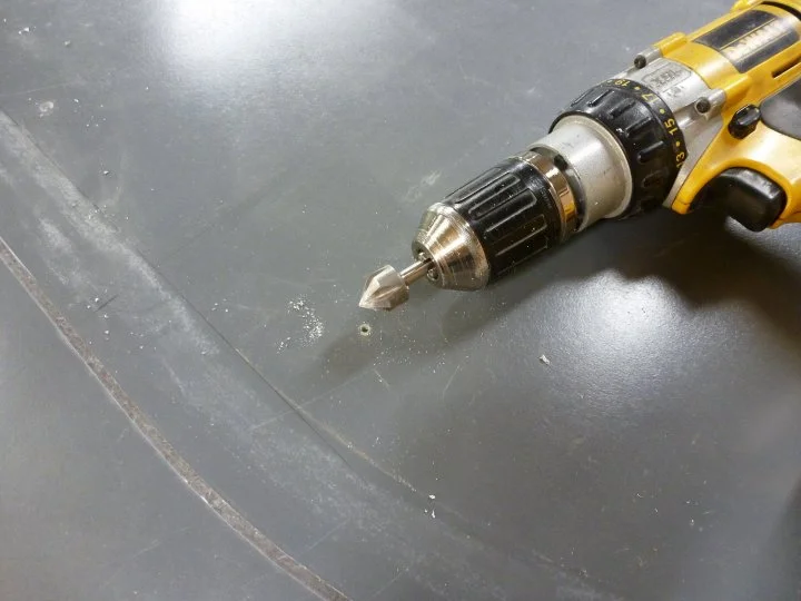 When patching something like this, whether it's a hole in fiberglass, drywall etc, you want to make it so your filler tapers and doesn't create a hard edge. I started by hitting all the screw holes with a counter sink bit.