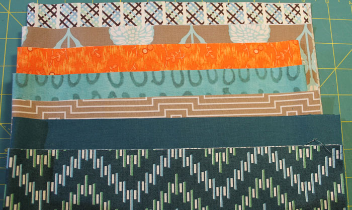The turquoise and orange fabrics were two I added. I eliminated a mustard yellow. The theme this year is Poetry and I have chose "Stopping By The Woods on a Snowy Evening" by Robert Frost. I have also added a white fabric with silver metallic swirls. I have just started quilting it and will share pictures soon.