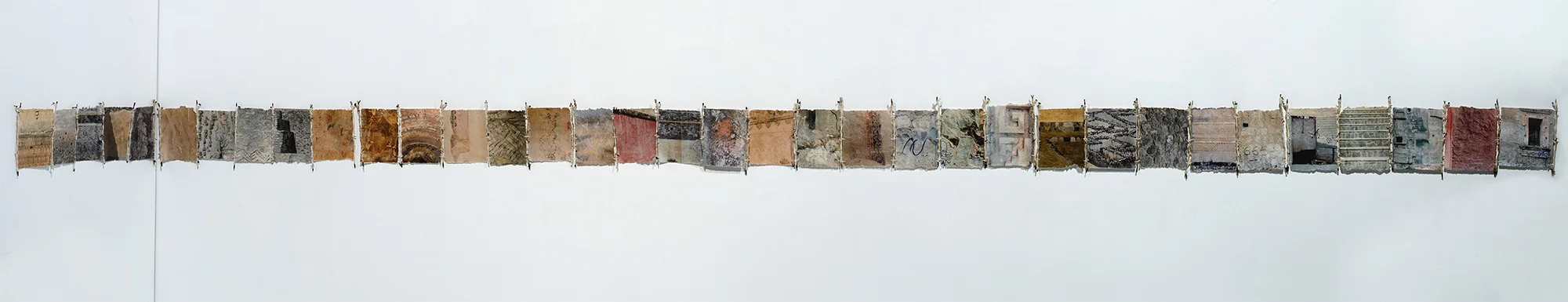wall constructions, installation view, 2018. 35 archival pigment digital mono-prints on artist-made paper from amate; stitched with silk thread, paper-wrapped barbed wire; 11 x 240 inches