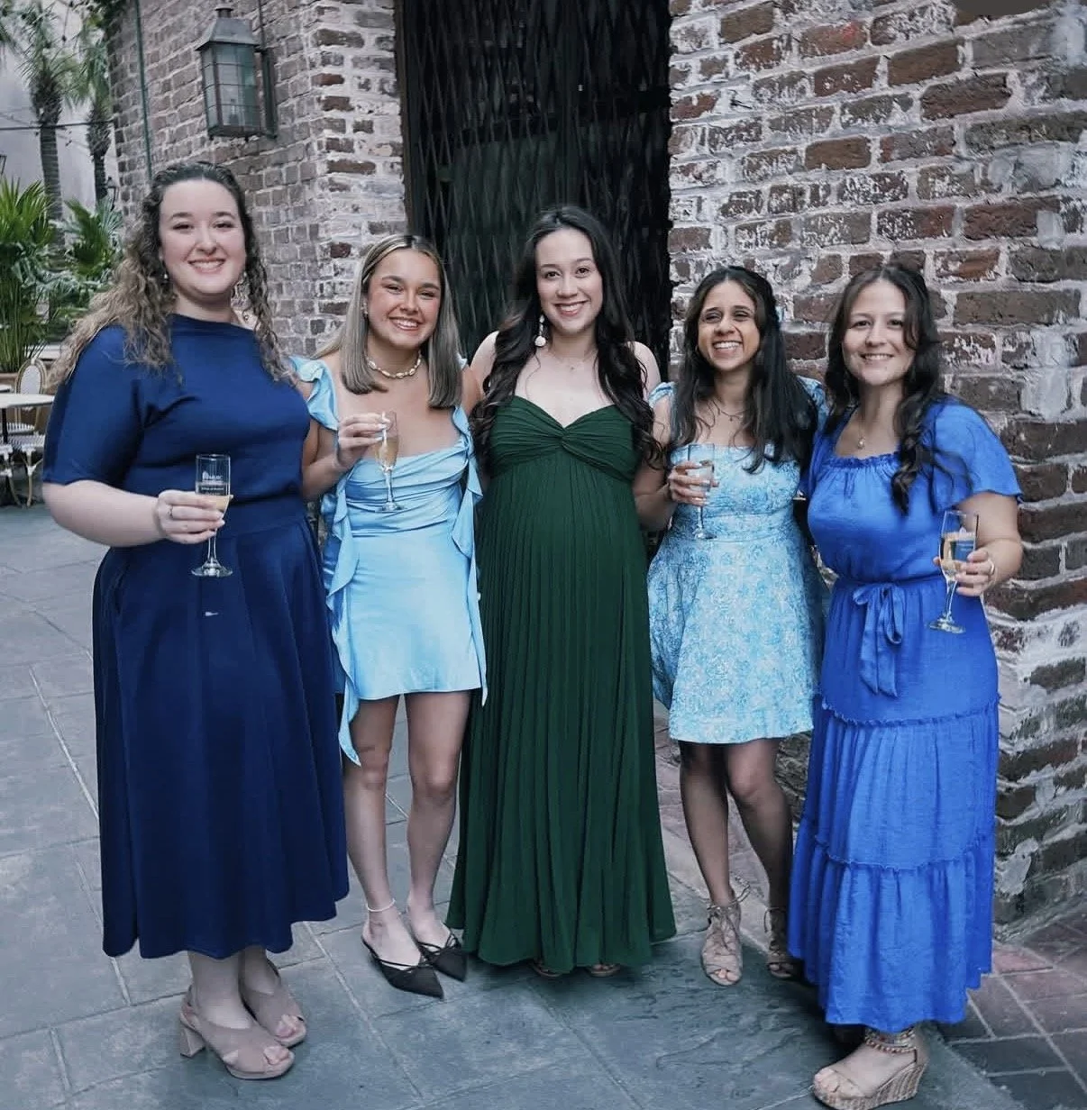 Group of new medical school graduates in dresses toasting
