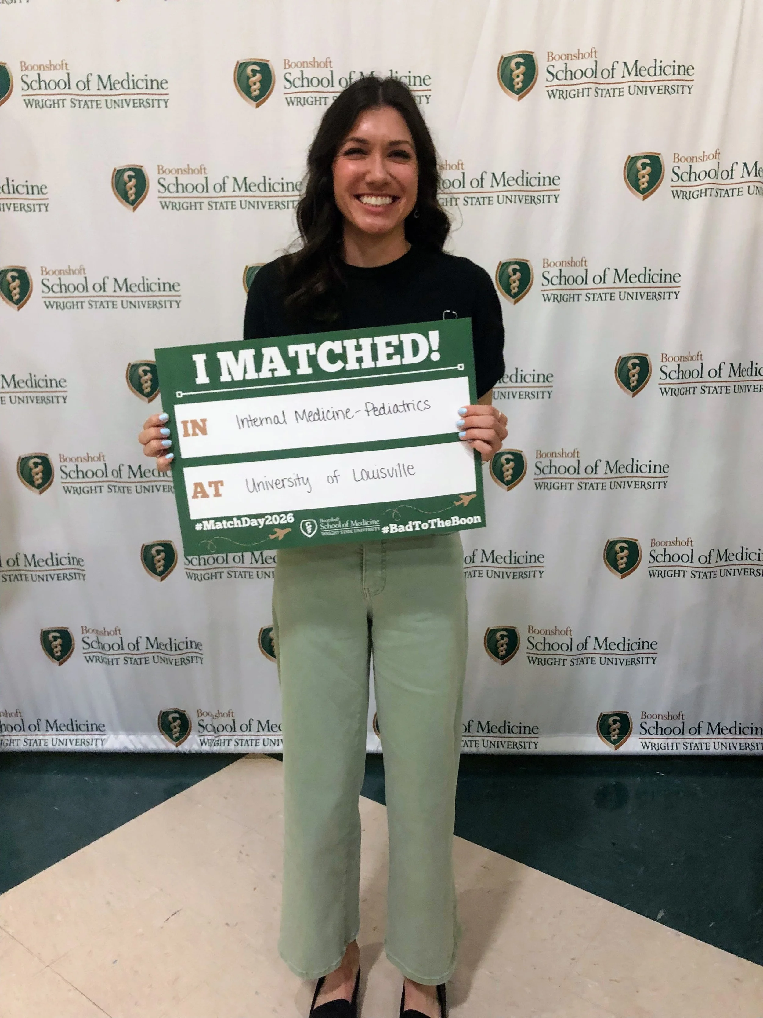 Brunette woman holding I matched Sign