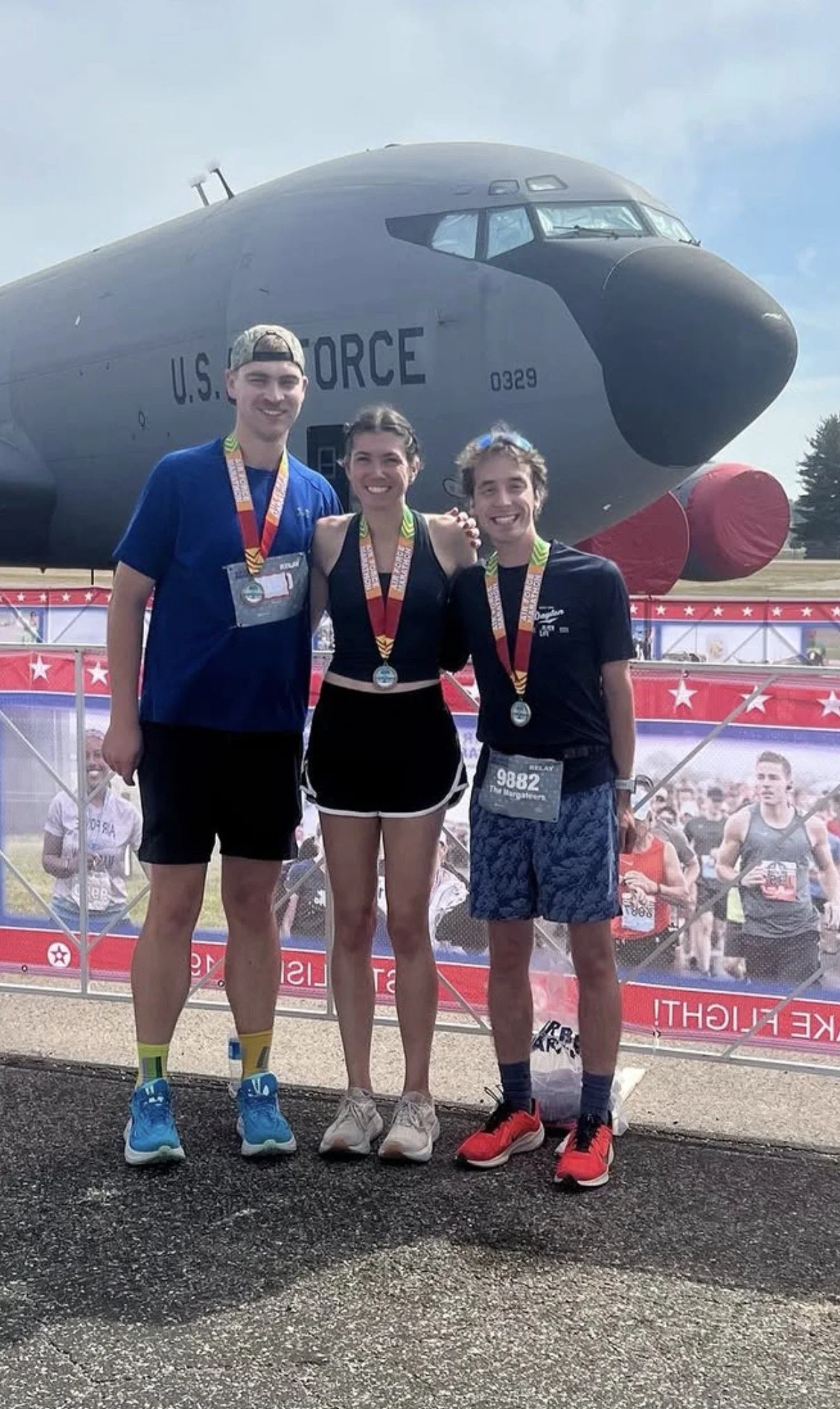 Group of three friends at a race with running medals