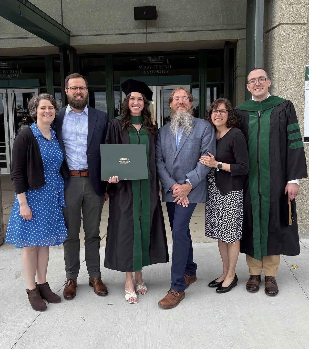 Young woman in med school cap and gown with a group of family and friends