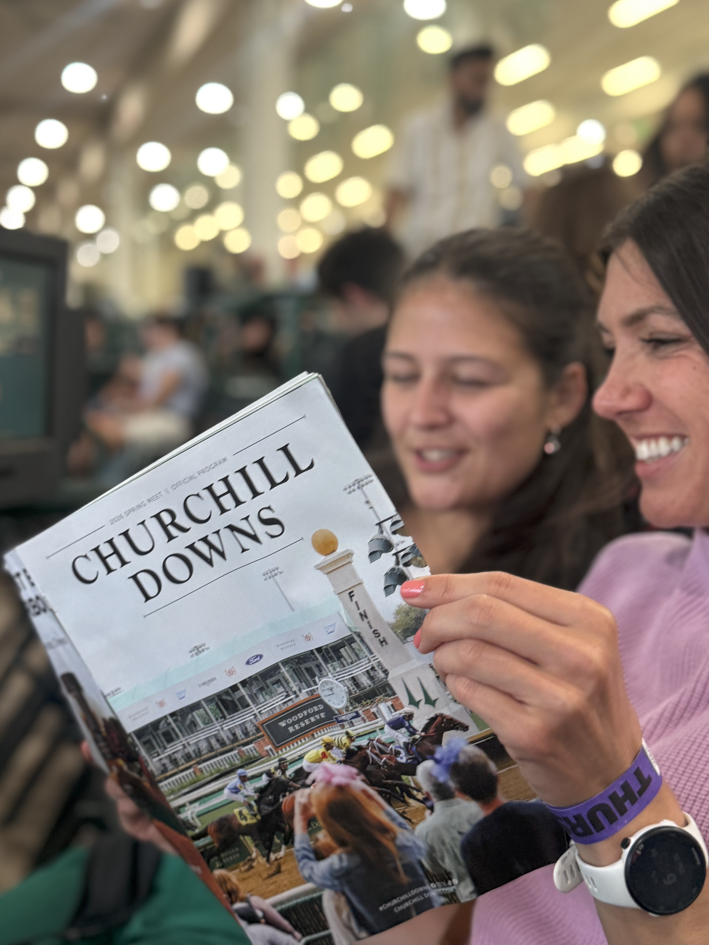 Two young women looking at a churchill downs racing book