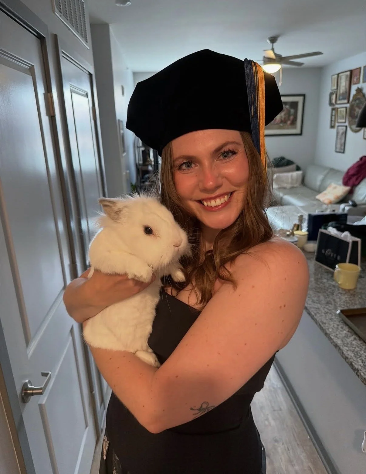 Young woman with graduation cap holding a bunny