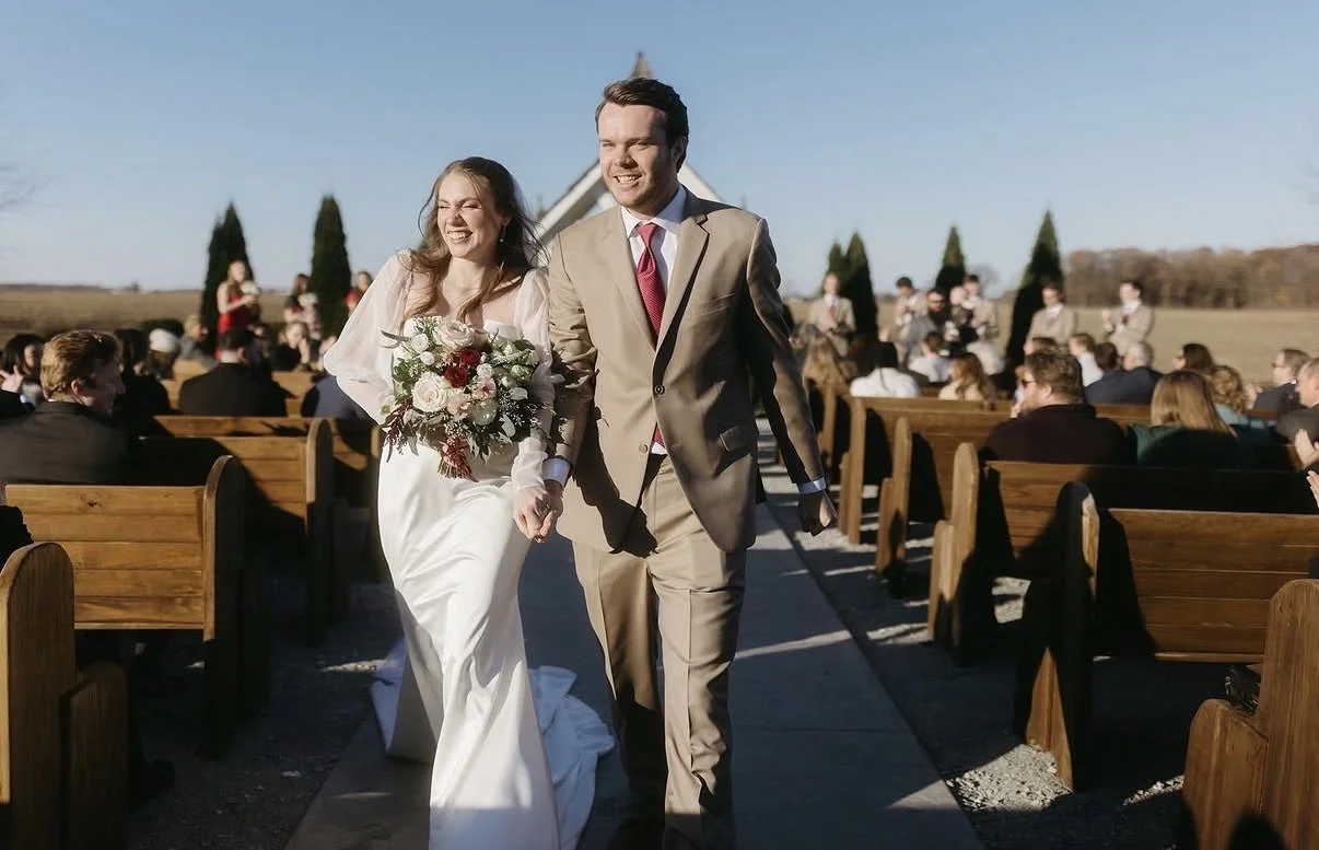 Man and woman walking down the aisle in wedding attire