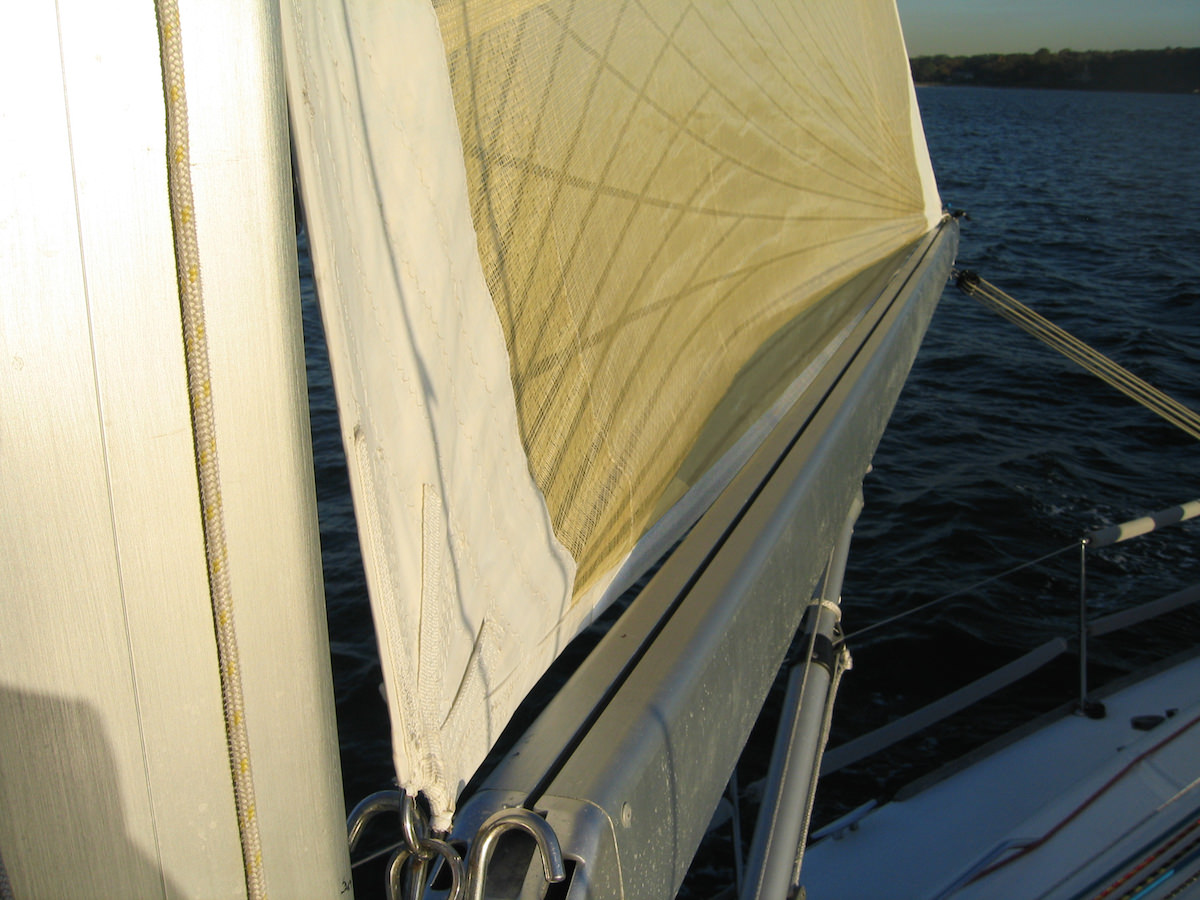 Not attaching the foot of the sail to the boom provides a much better aerodynamic shape without reducing strength.