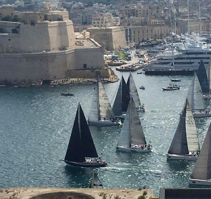 Libby O'Brien's photo showing TRIPLE LINDY (black sails and fixed sprit) winning the start of IRC Class 5 of the 2017 Rolex Middle Sea Race.