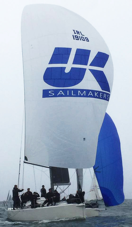 The J/109 OUTRAJEOUS sailing with her symmetrical spinnaker nearly dead downwind.