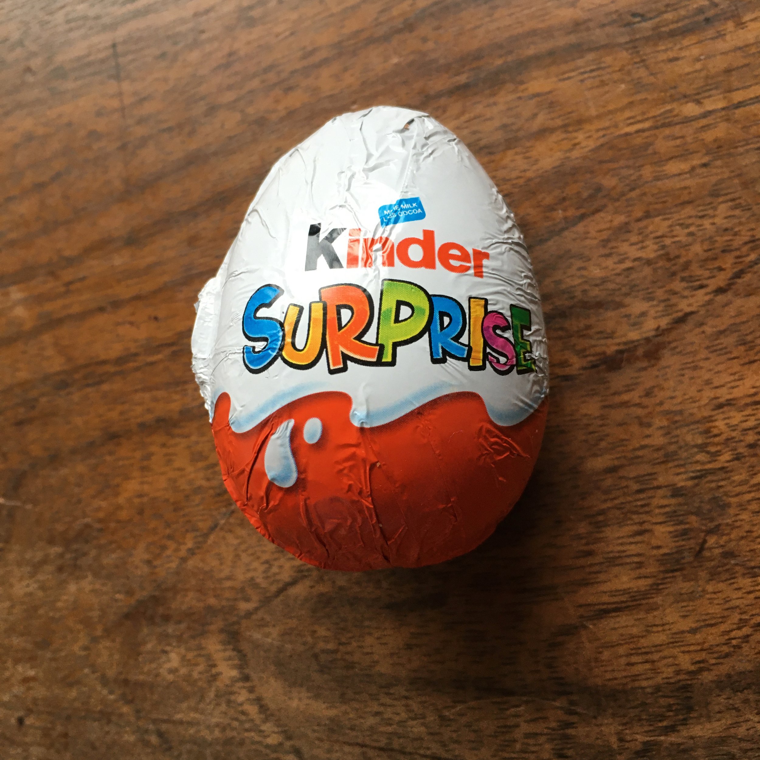  a Kinder Surprise egg: a larger-than-a-hen’s-egg chocolate egg wrapped in orange and white foil 