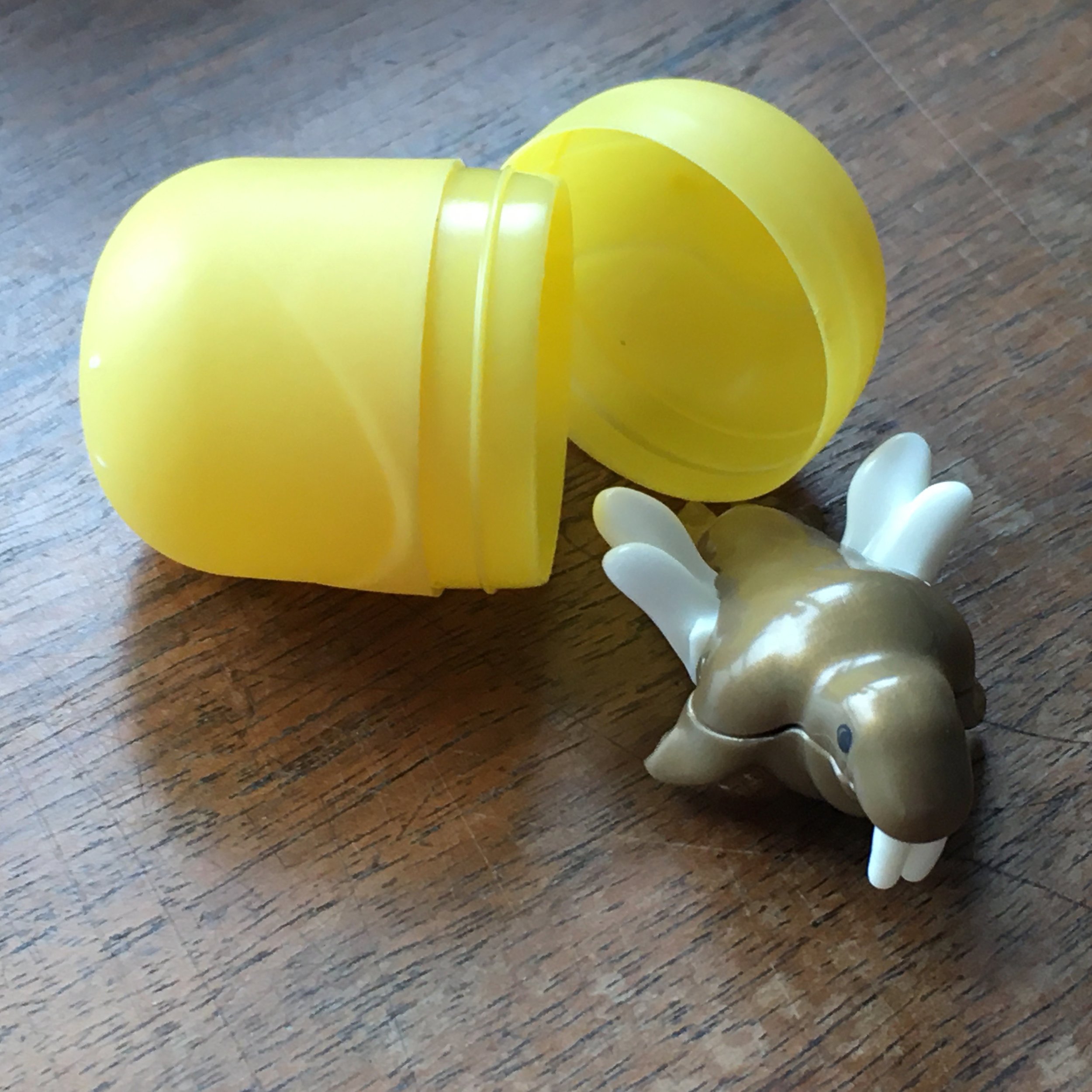  the yolk capsule open, hatching a plastic toy walrus with wings 