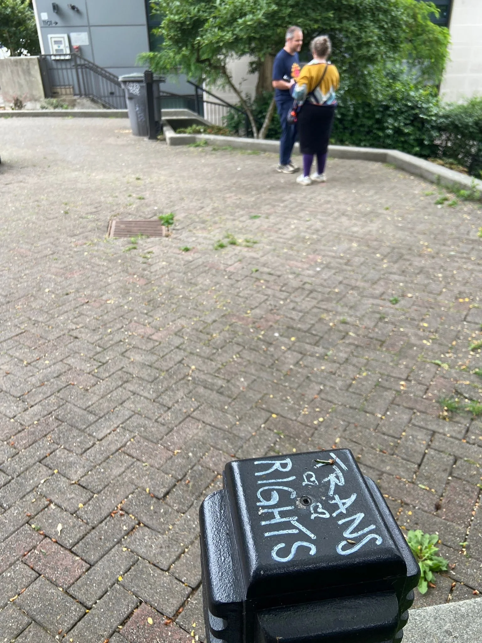   Choklit Park : Helen and Justin record in the distance. Choklit Park says Trans Rights. 