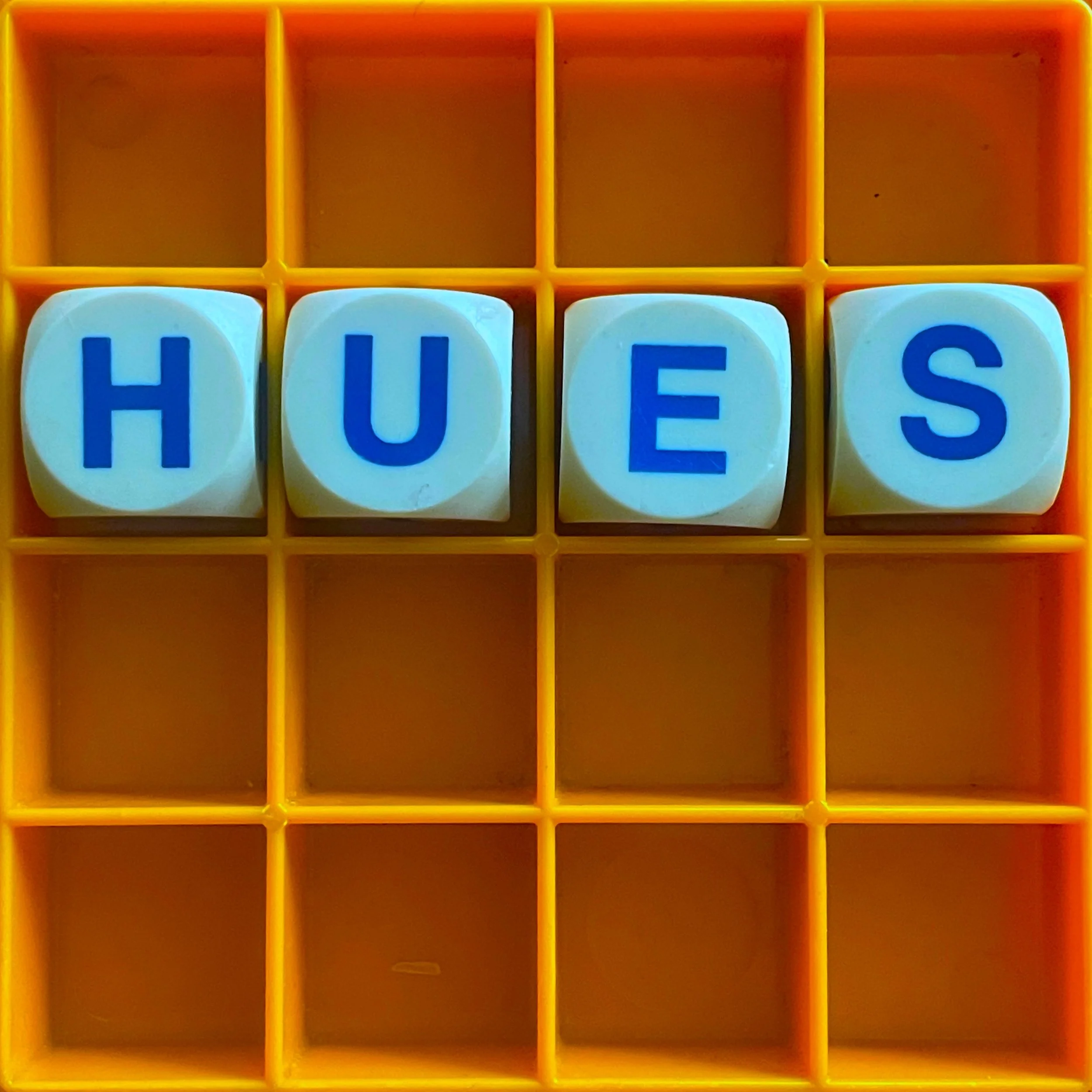A boggle set spelling out the word 'hues' as in colours
