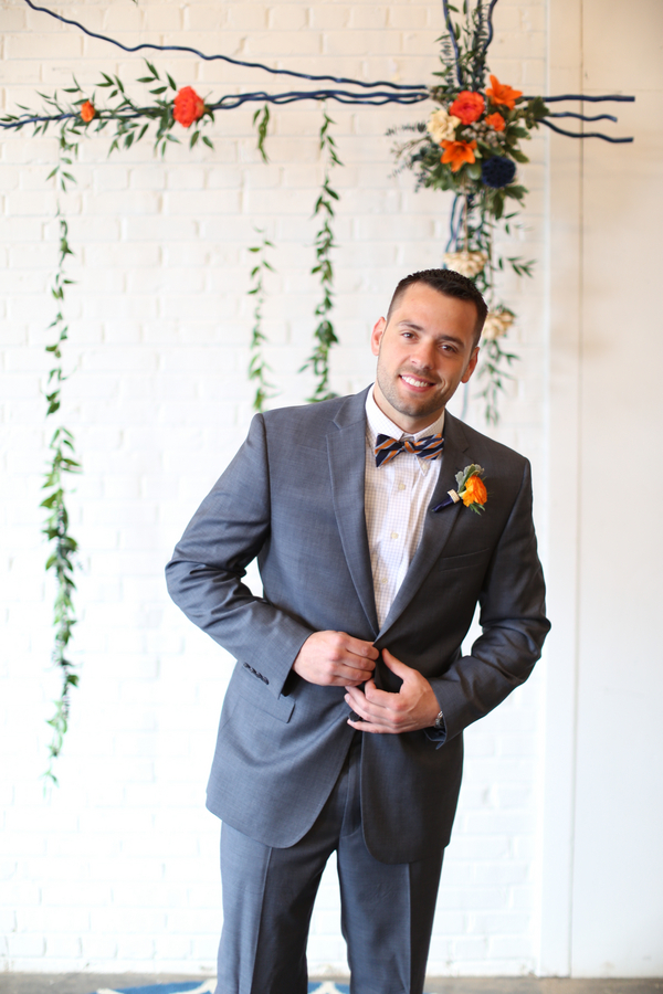 Groom in a grey suit with orange and blue bowtie