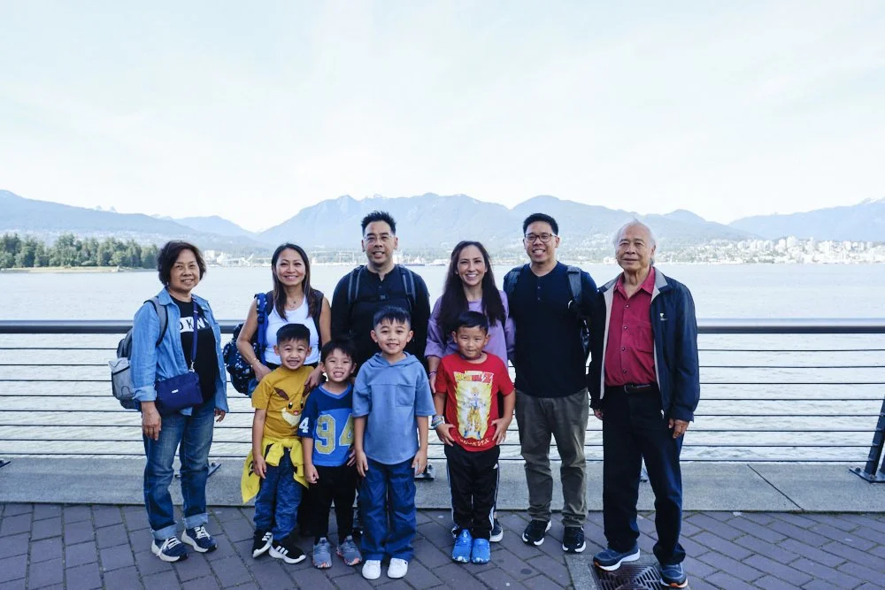 Family group photo at Jack Poole Plaza in Vancouver with the mountains and harbor behind