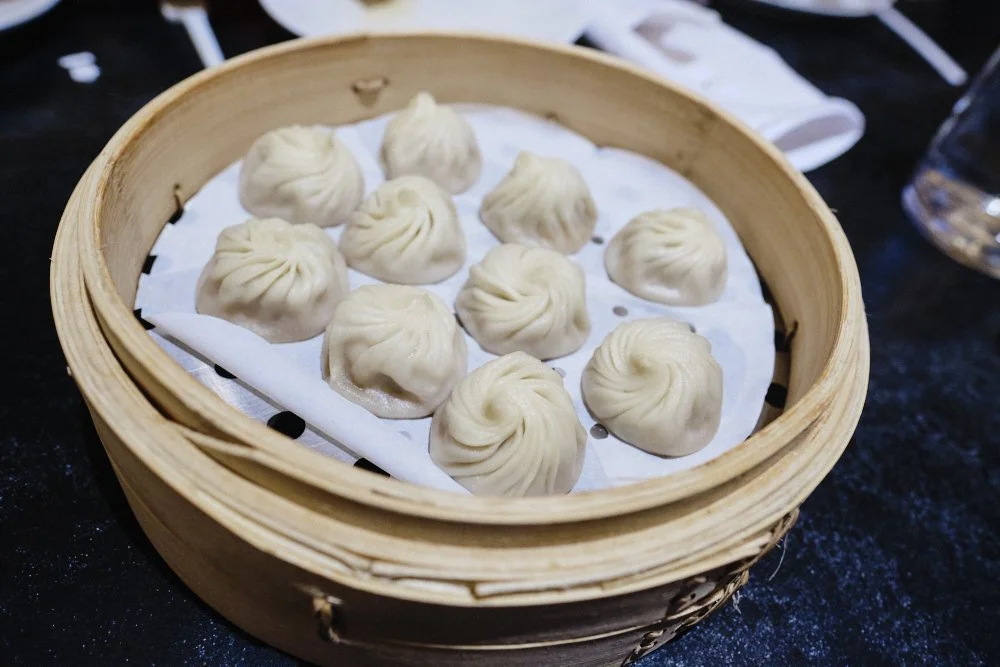 Steamed xiaolongbao dumplings served in a bamboo basket at Din Tai Fung Vancouver