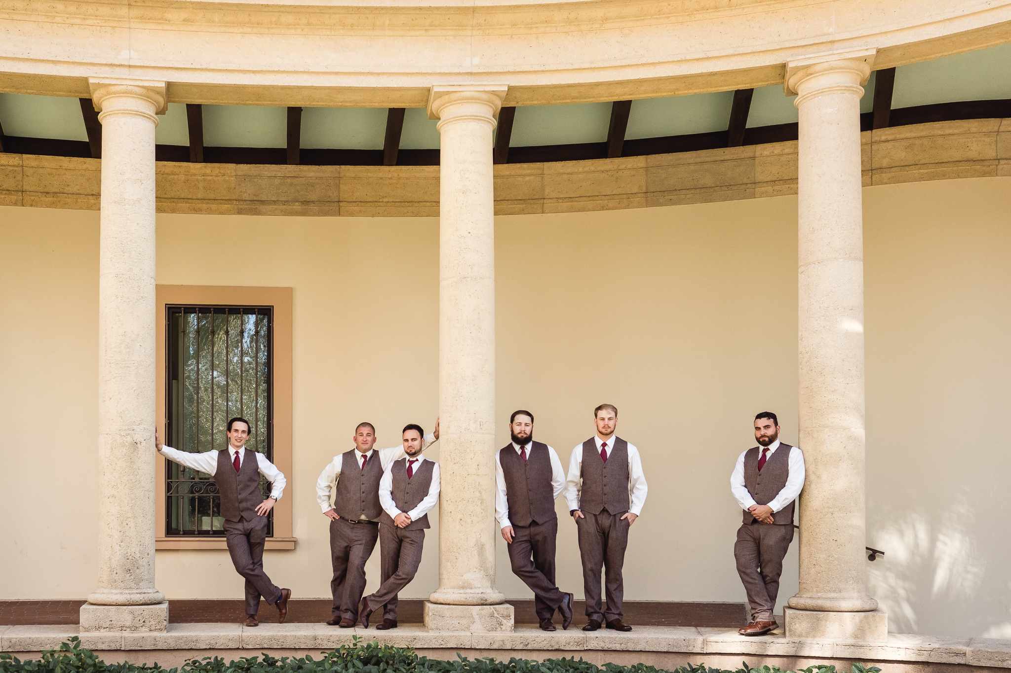 Groom and groomsmen pose by columns outside the Museum of Fine Arts in downtown St. Petersburg, Florida