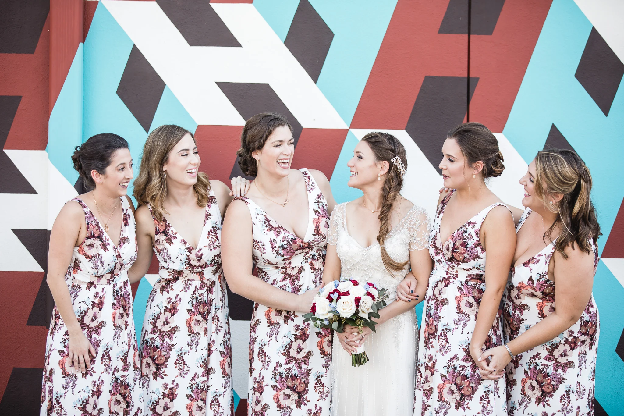 Photograph of bride and bridesmaids by artistic wall at the Hollander Hotel in St. Petersburg, Florida