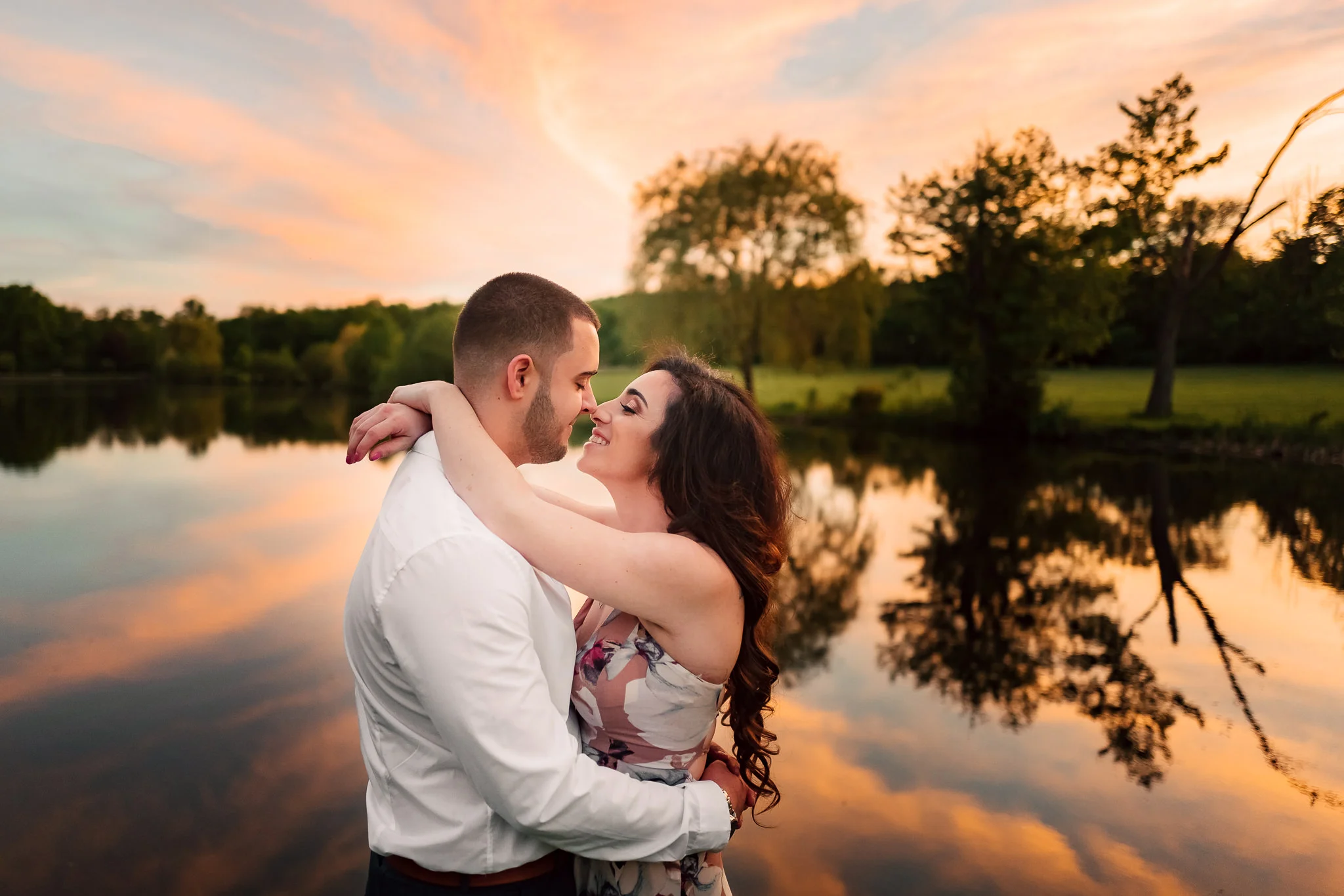 Engaged Couple Embracing and Touching Noses During an Orange and Blue Sunset sky at Verona Park New Jersey