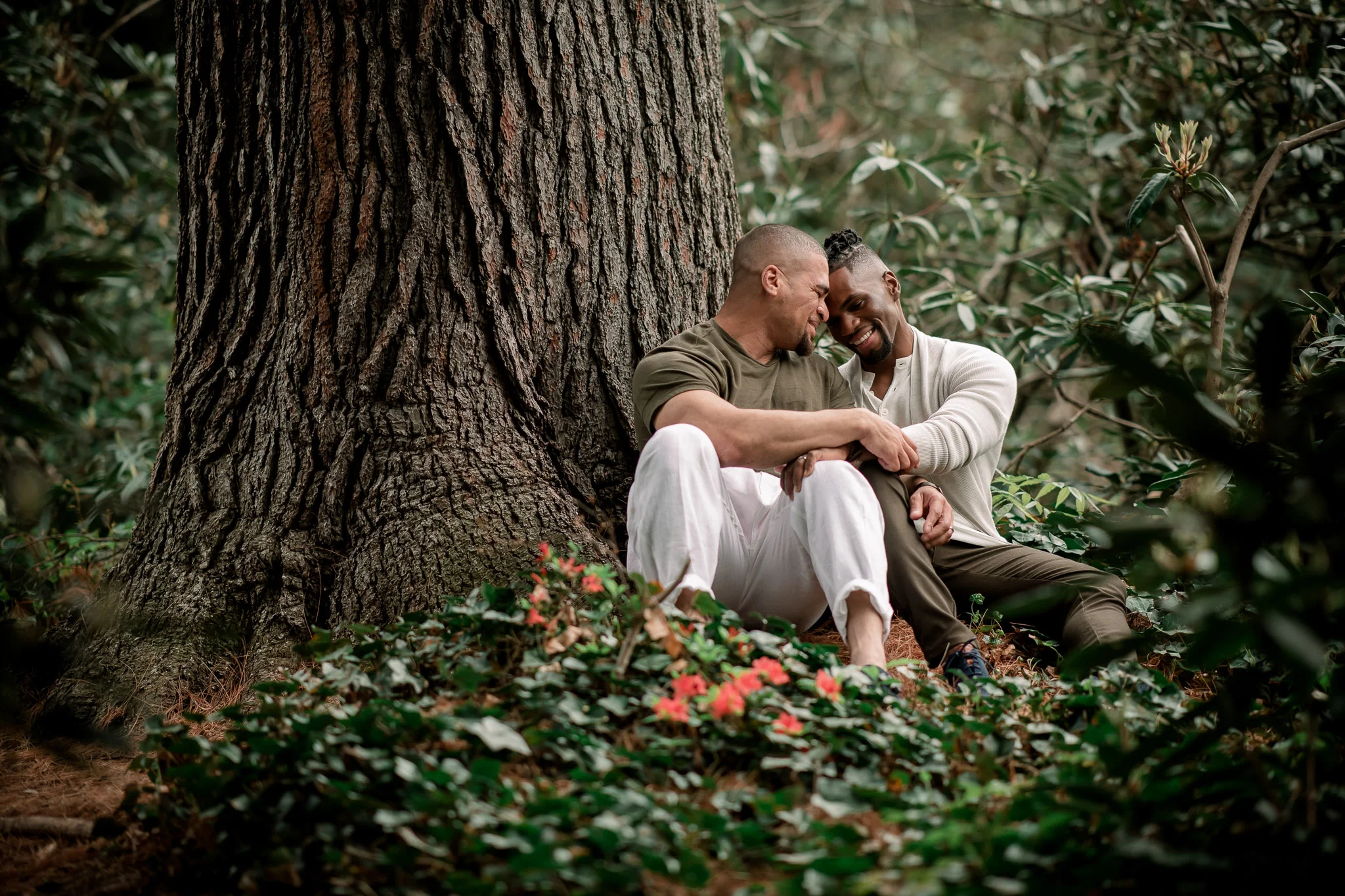 Same Sex Couple Sitting By Tree and Green Scenery at Van Vleck House and Gardens in Montclair, New Jersey