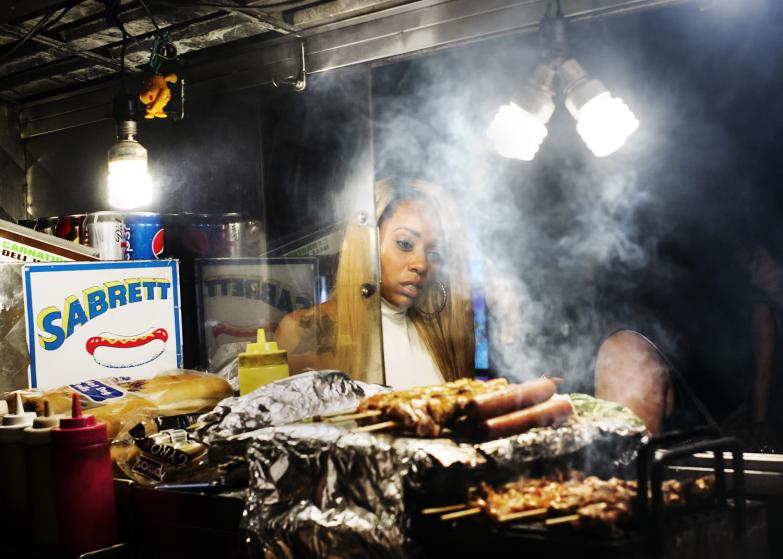 A woman buys a hot dog late at night in August 2014 .