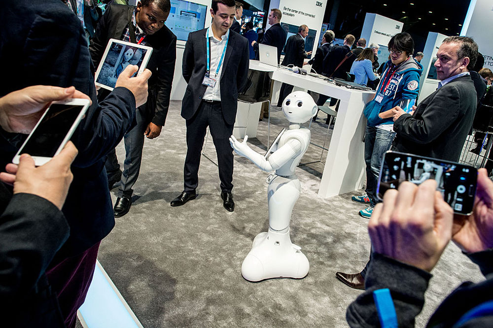 Visitors attend a demonstration of a robot named ‘Pepper’ at the IBM stand on day 3 of the Mobile World Congress 2016 on February 24, 2016 in Barcelona, Spain. The annual Mobile World Congress hosts some of the world’s largest communications companies, with many unveiling their latest phones and wearables gadgets. Photo: David Ramos/Getty Images.