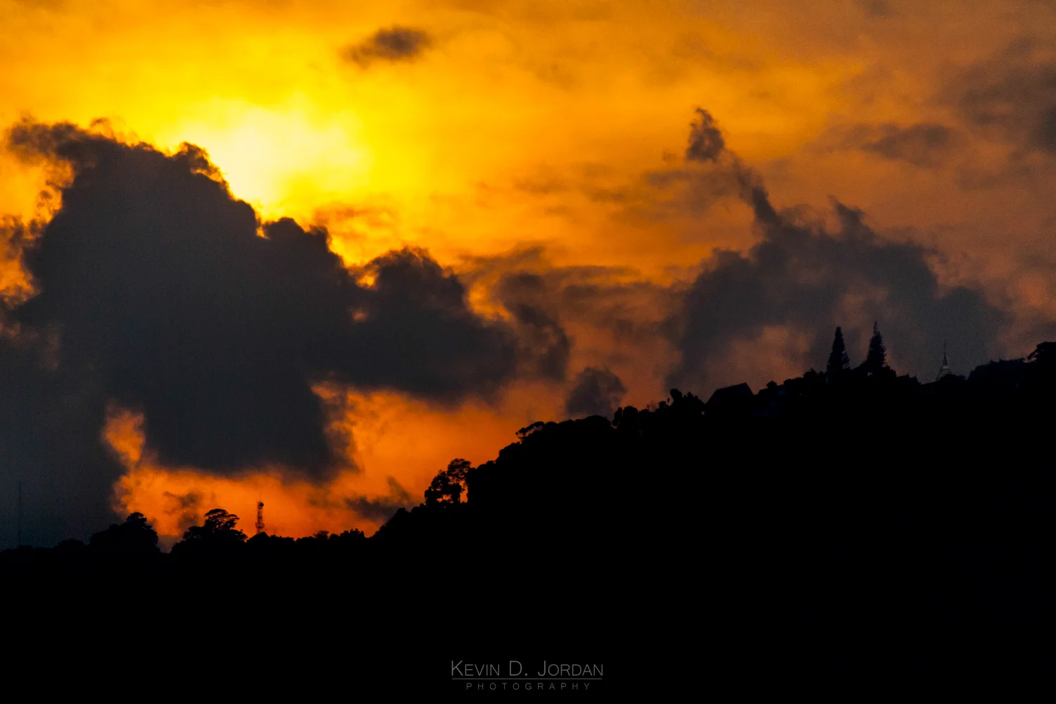 View of Wat Phra That from Chiang Mai during sunset. The golden spire of the temple can be seen on the far right side of the ridge line (© Kevin D. Jordan Photography)