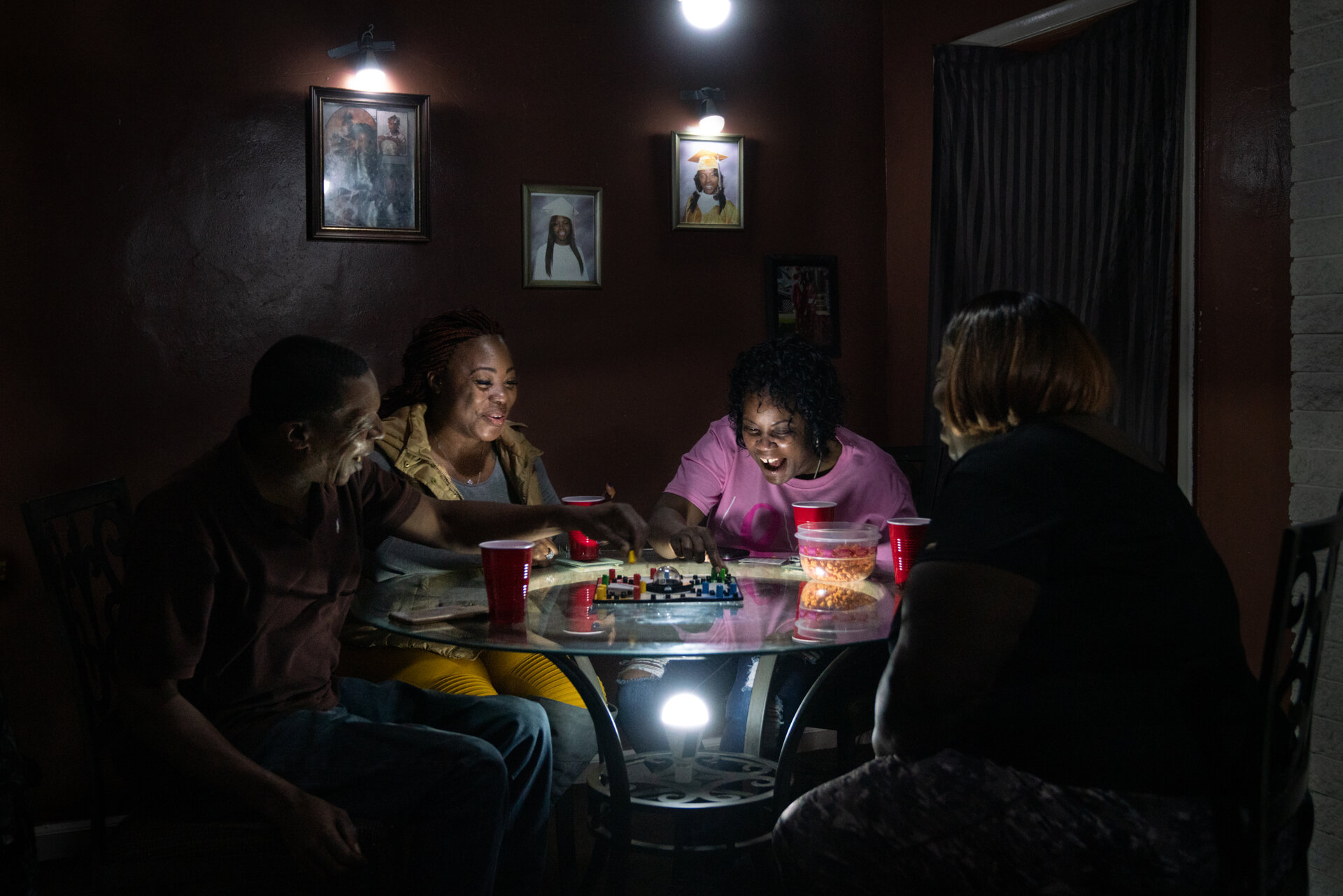  Shavone Travick enjoys a weekly game night with friends and family, lit by the glow of a solar powered home. 
