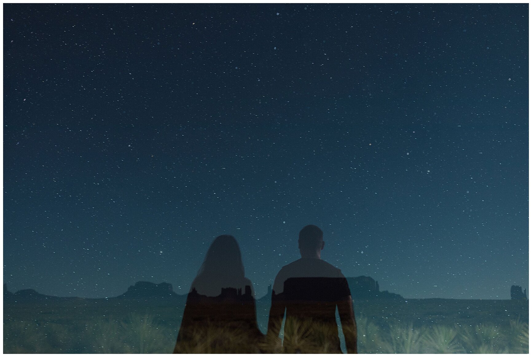 engaged couple holding hands under the starry night sky in the desert in monument valley arizona