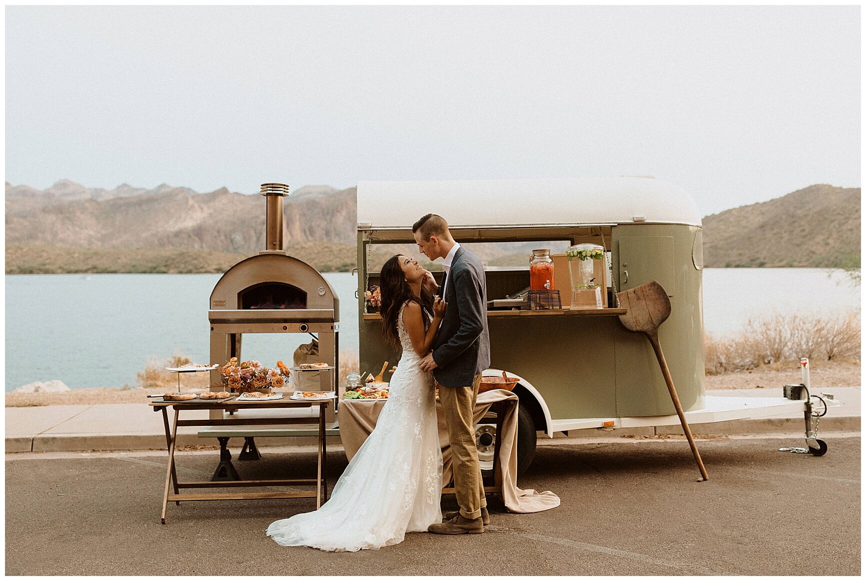 bride and groom holding hands in front of a pizza food truck during their saguaro lake elopement