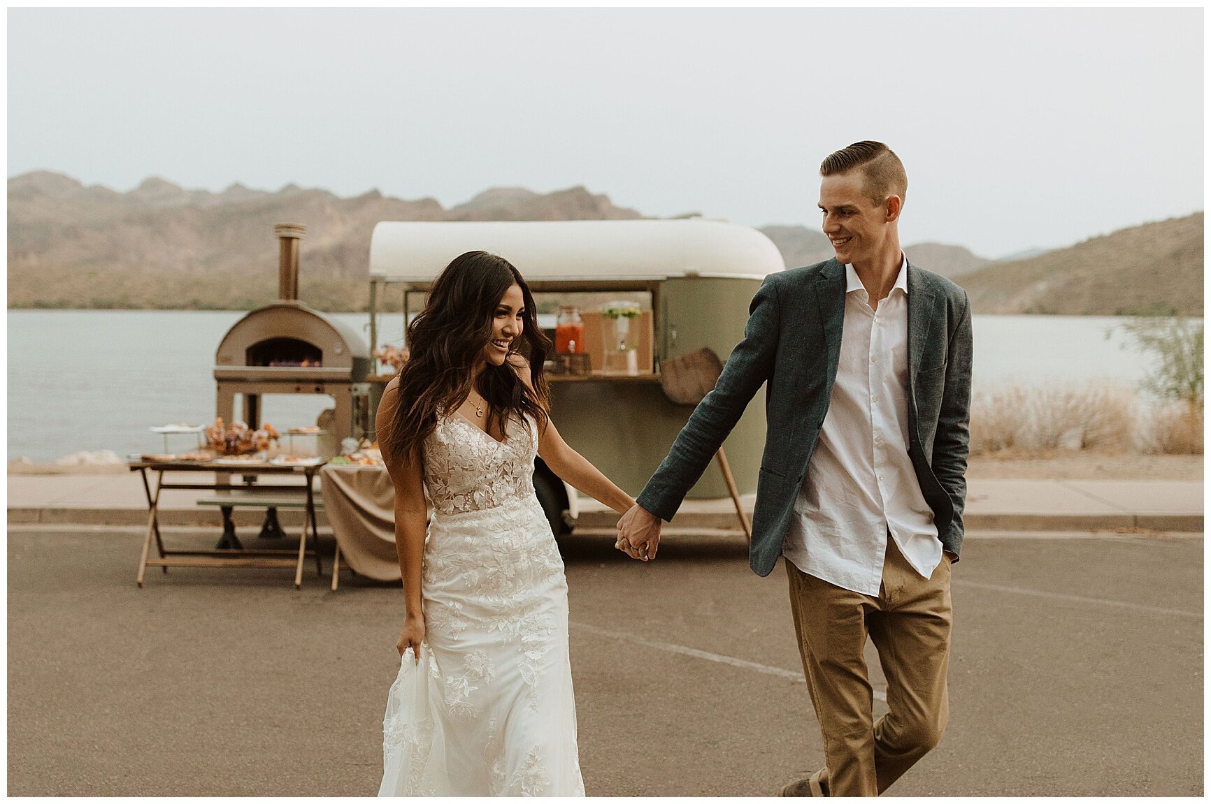 bride and groom holding hands in front of a pizza food truck during their saguaro lake elopement