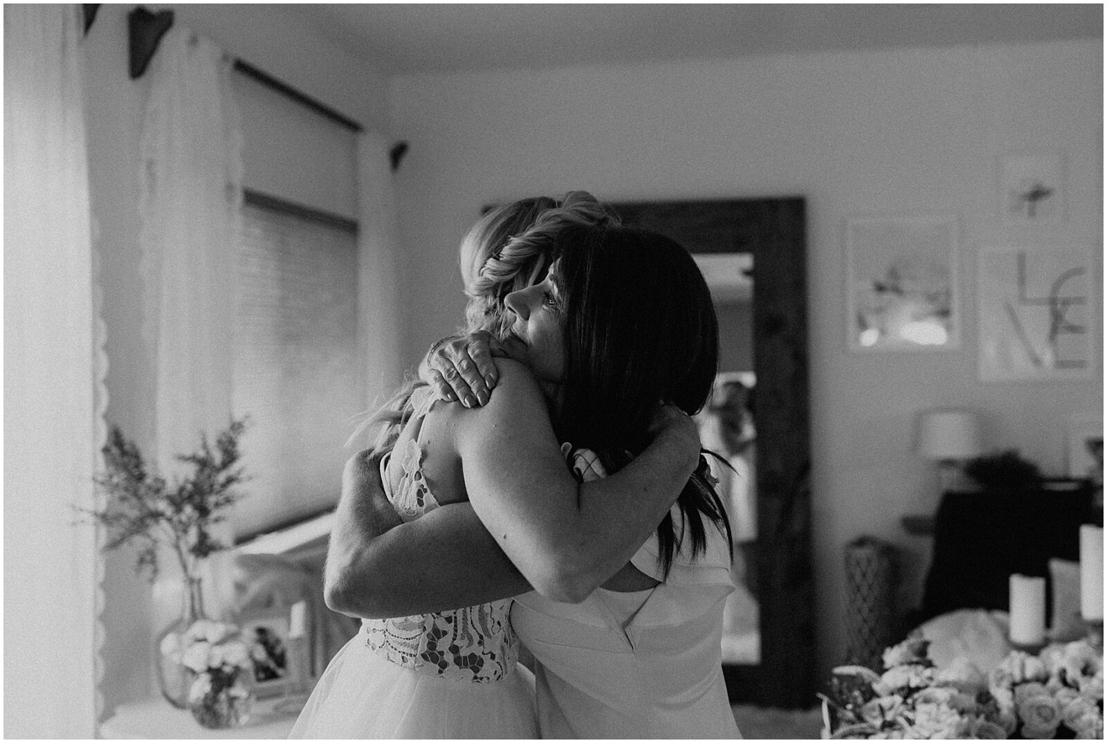 bride and mother of the bride hugging on wedding day