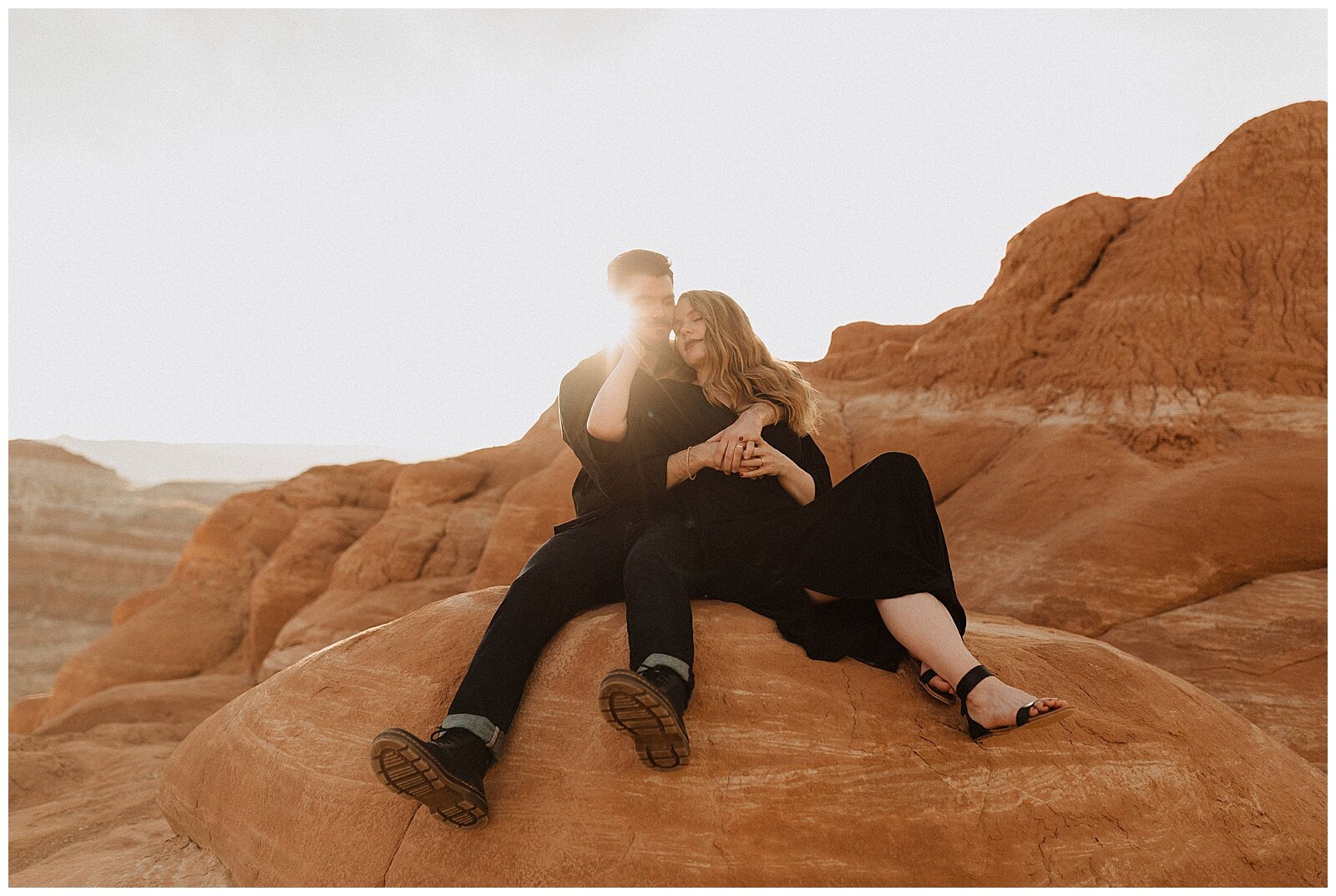 engaged couple wearing black and posing for portraits in grand escalante