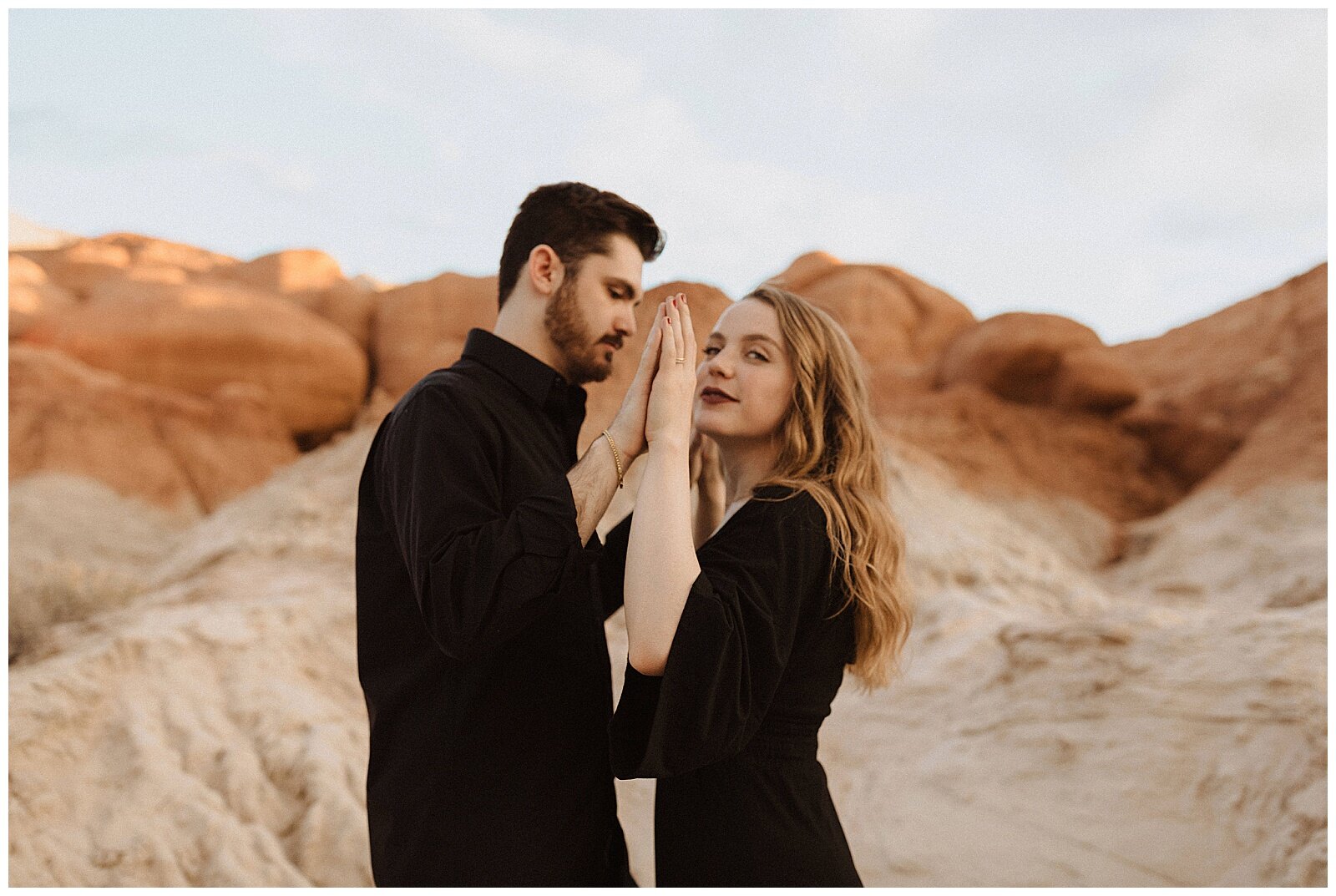 engaged couple wearing black and posing for portraits in grand escalante