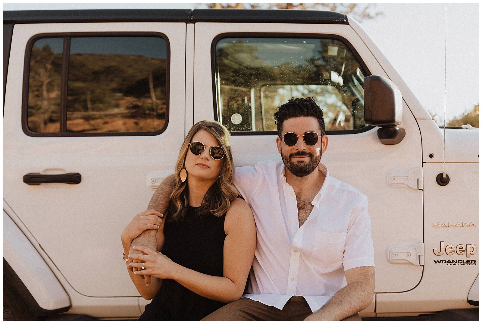 couple posing in front of white jeep for their Sedona engagement session 