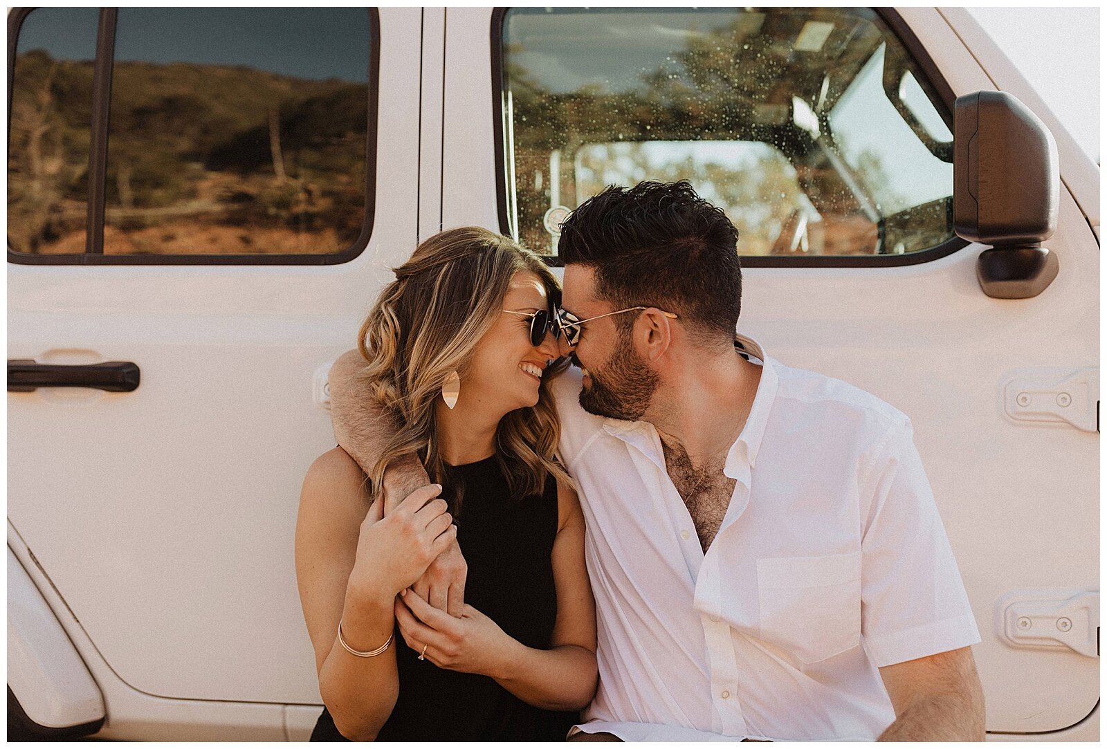 couple posing in front of white jeep for their Sedona engagement session 
