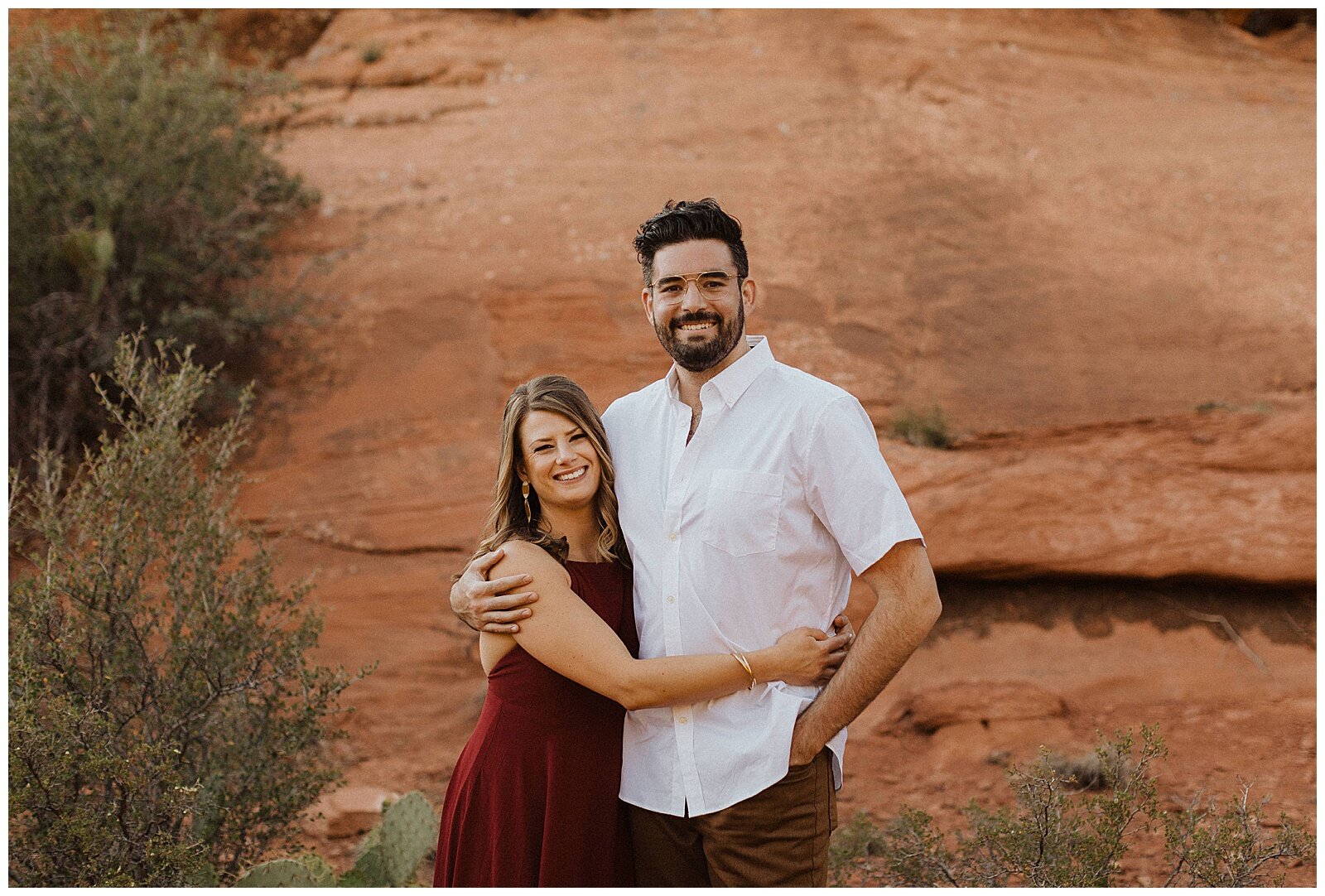 couple hugging in front of red rocks for their sedona engagement session 