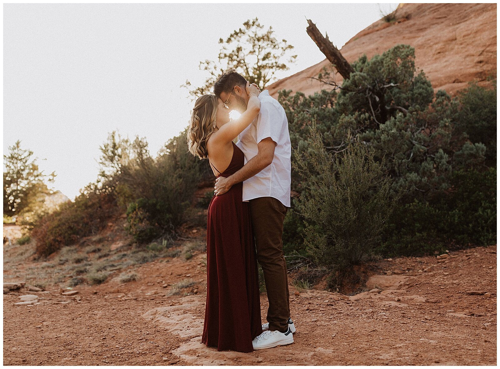 couple hugging in front of red rocks for their sedona engagement session 