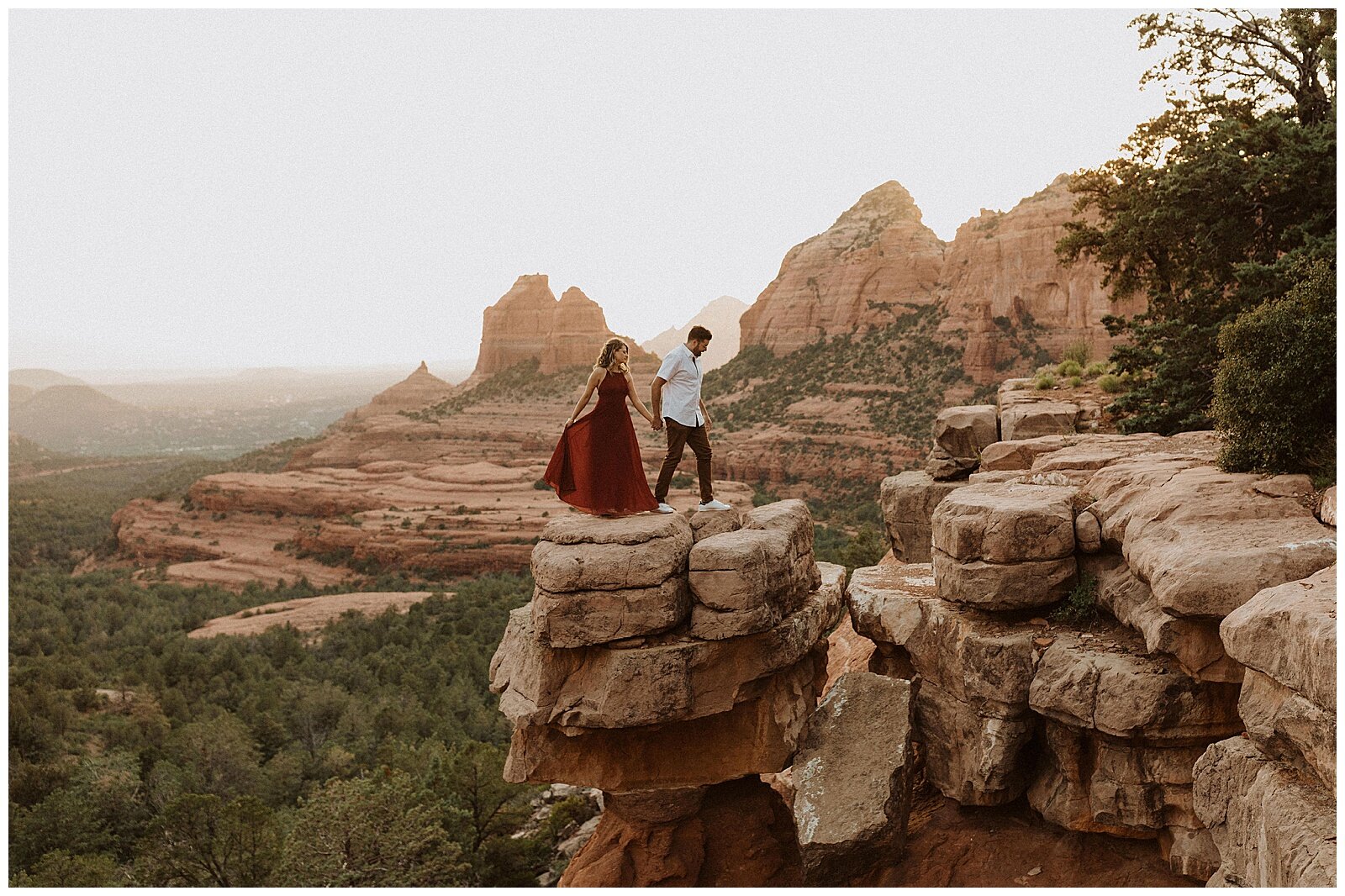 couple standing on top of red rocks during their sedona engagement session 