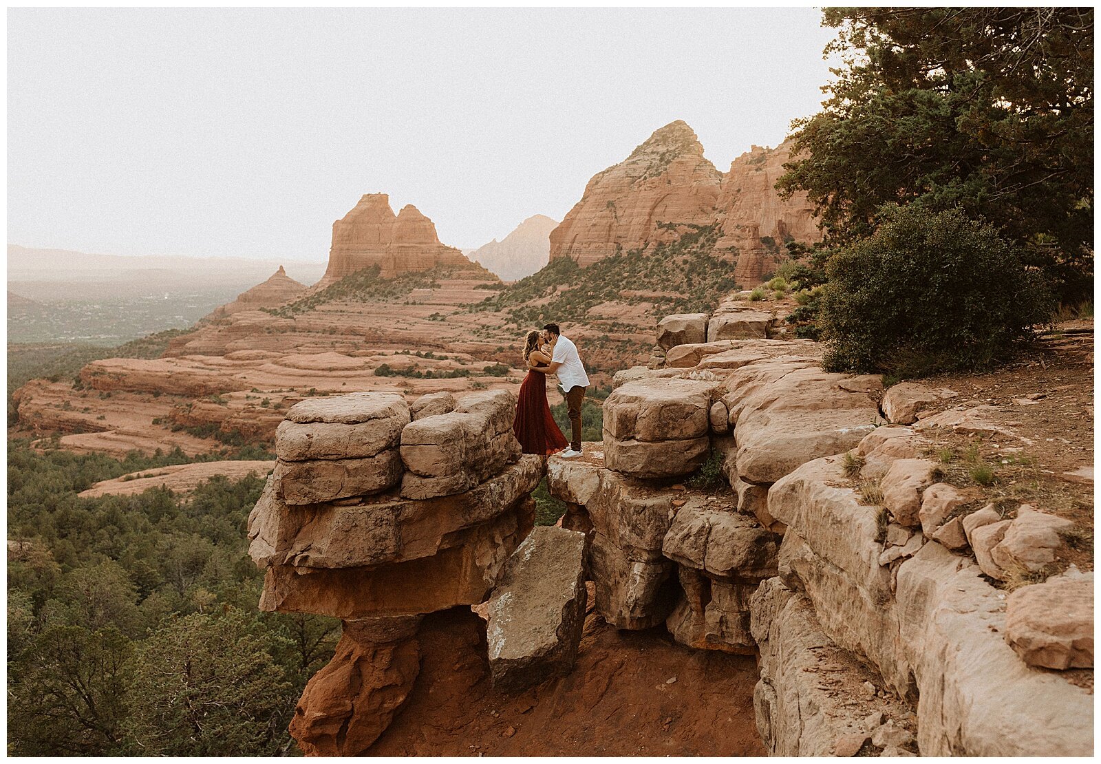 couple standing on top of red rocks during their sedona engagement session 