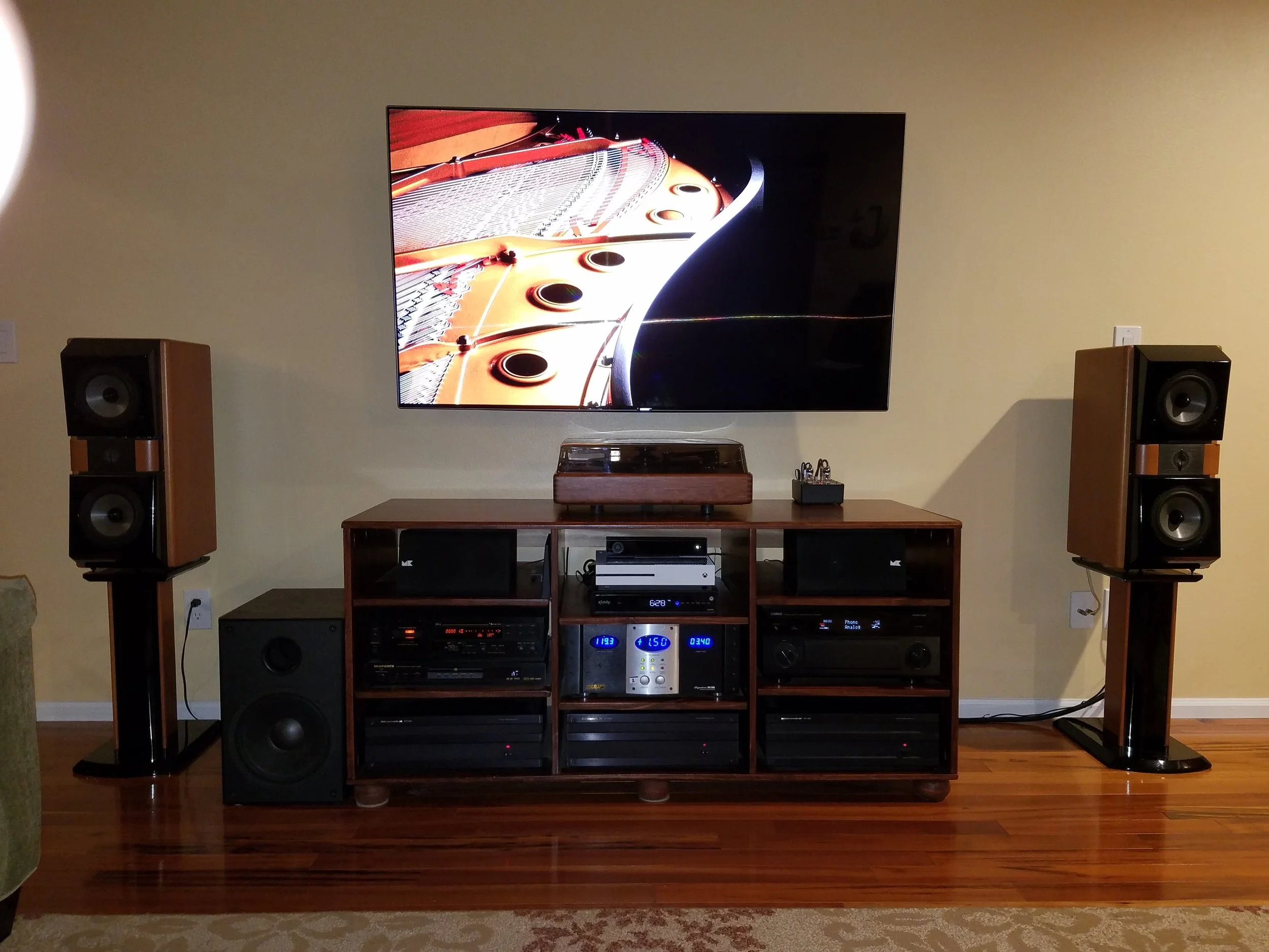 Todd C System : Yamaha CA-5100, 3 x B&K ST-1400 amplifiers, Monster AVS-2000 voltage stabilizer, Marantz DV-6600, Nakamichi DR-3, SOTA Star Sapphire Series 5 turntable, REGA RB-303 tonearm, Sumiko Virtuoso Boron MCC, Budgie tube phono preamp, X-Box One S, Nvidia Shield, JM Lab (Focal) Mini Utopia’s (front), M&K S-85’s (center), KEF Q70’s (rear), Focal Cub (sub), Samsung 65” 4k. DANG!