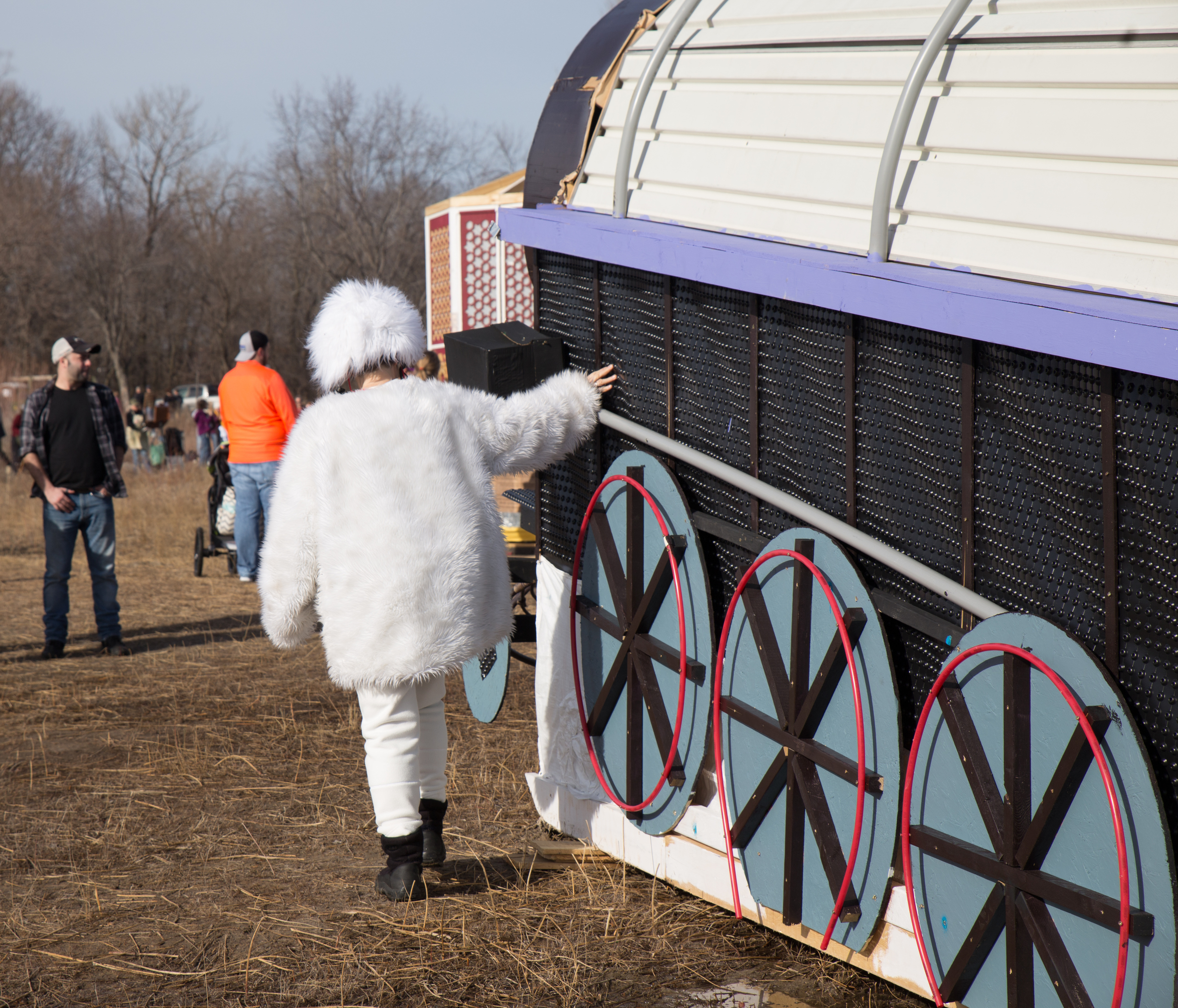 A Pedal Bear Bike driver walks by the Peace Train Shanty